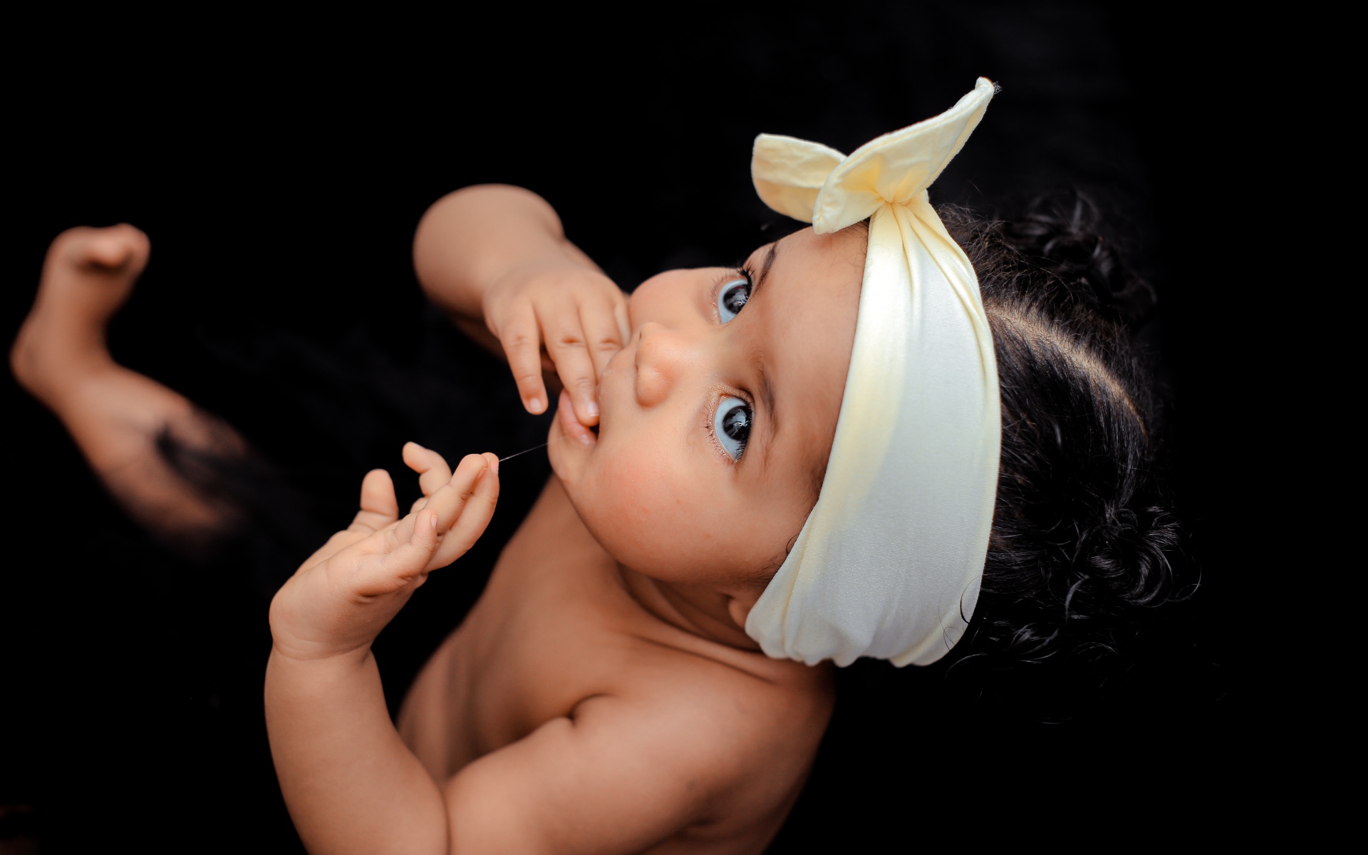 Маленькая темноволосая девочка с бантом на голове 