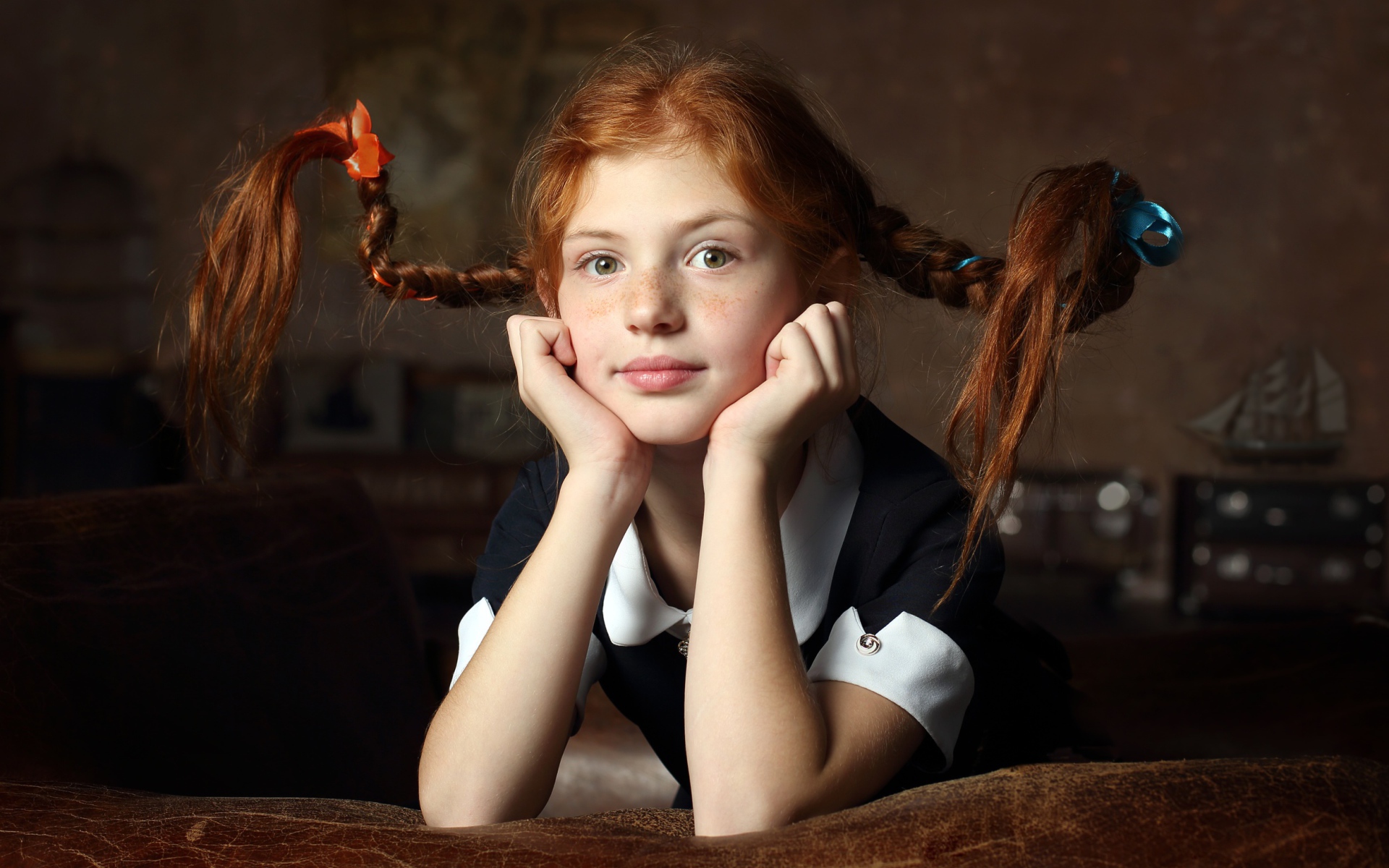 Маленькая смешная девочка с косами в школьной форме 