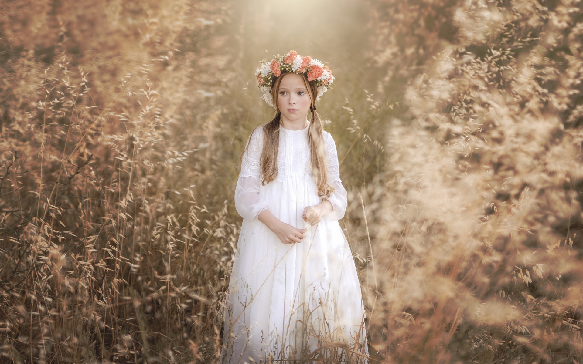 Маленькая девочка в белом платье с венком на голове 