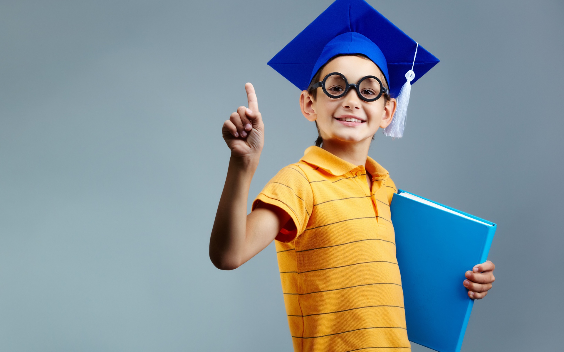 Маленький ученый мальчик с книгой в руке 