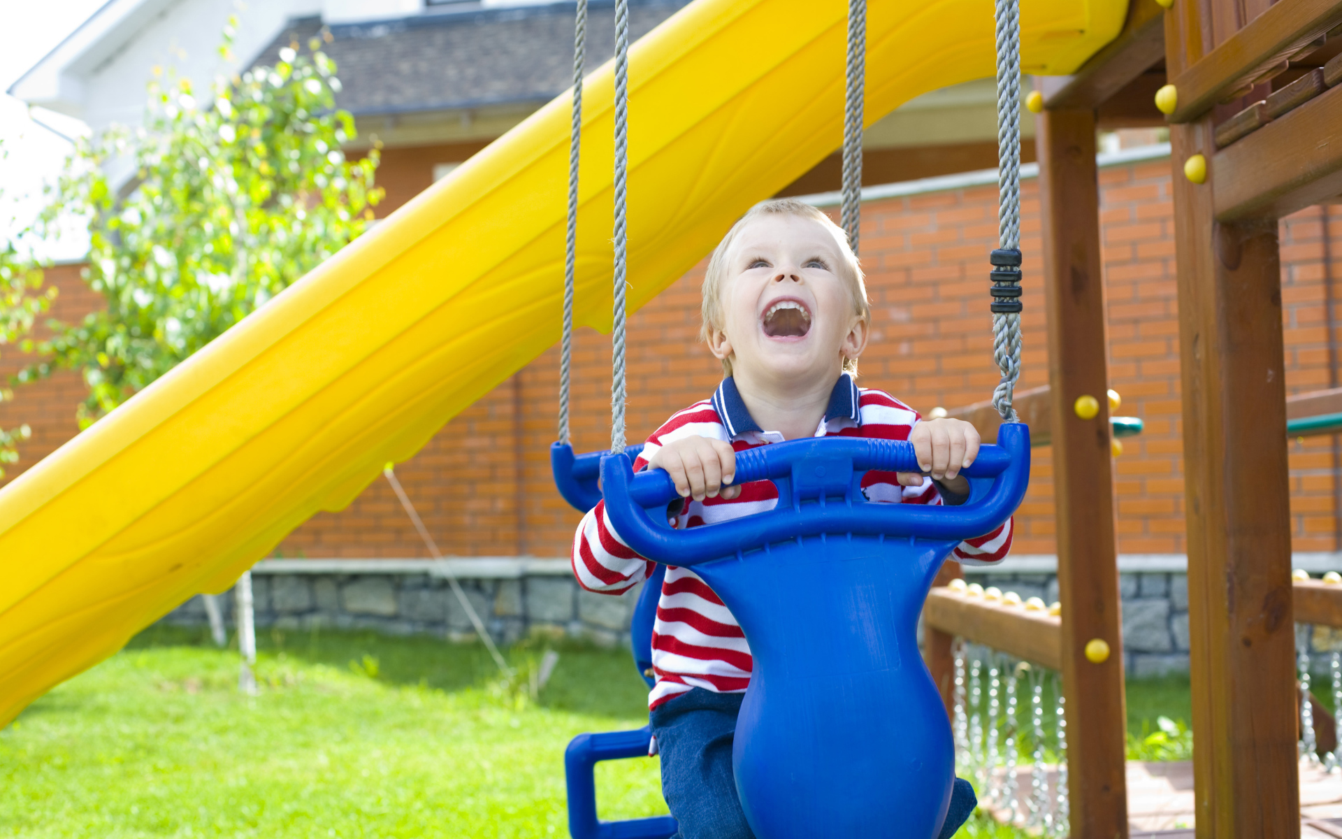 Улыбающийся ребенок на качели 