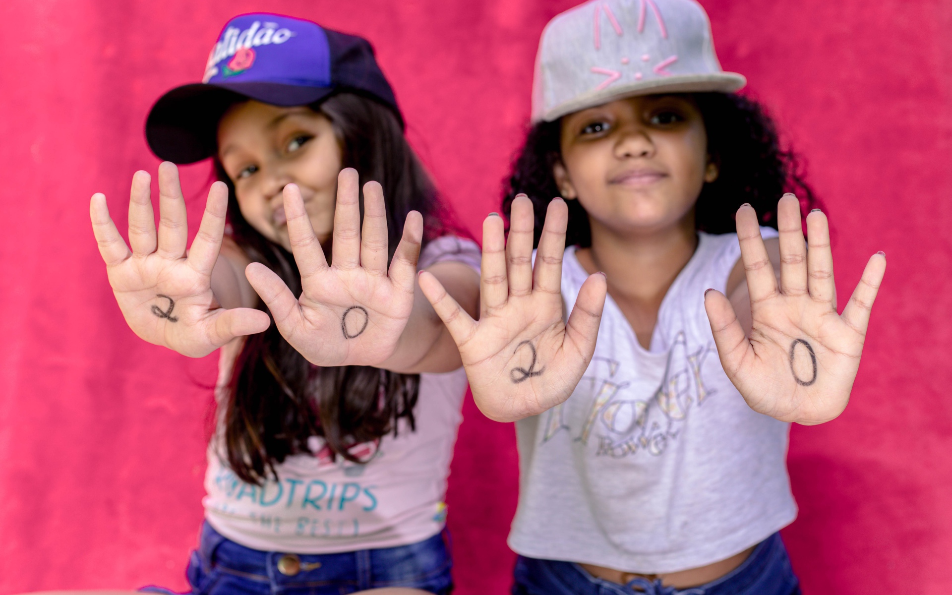 Две маленькие девочка с цифрами на ладонях 