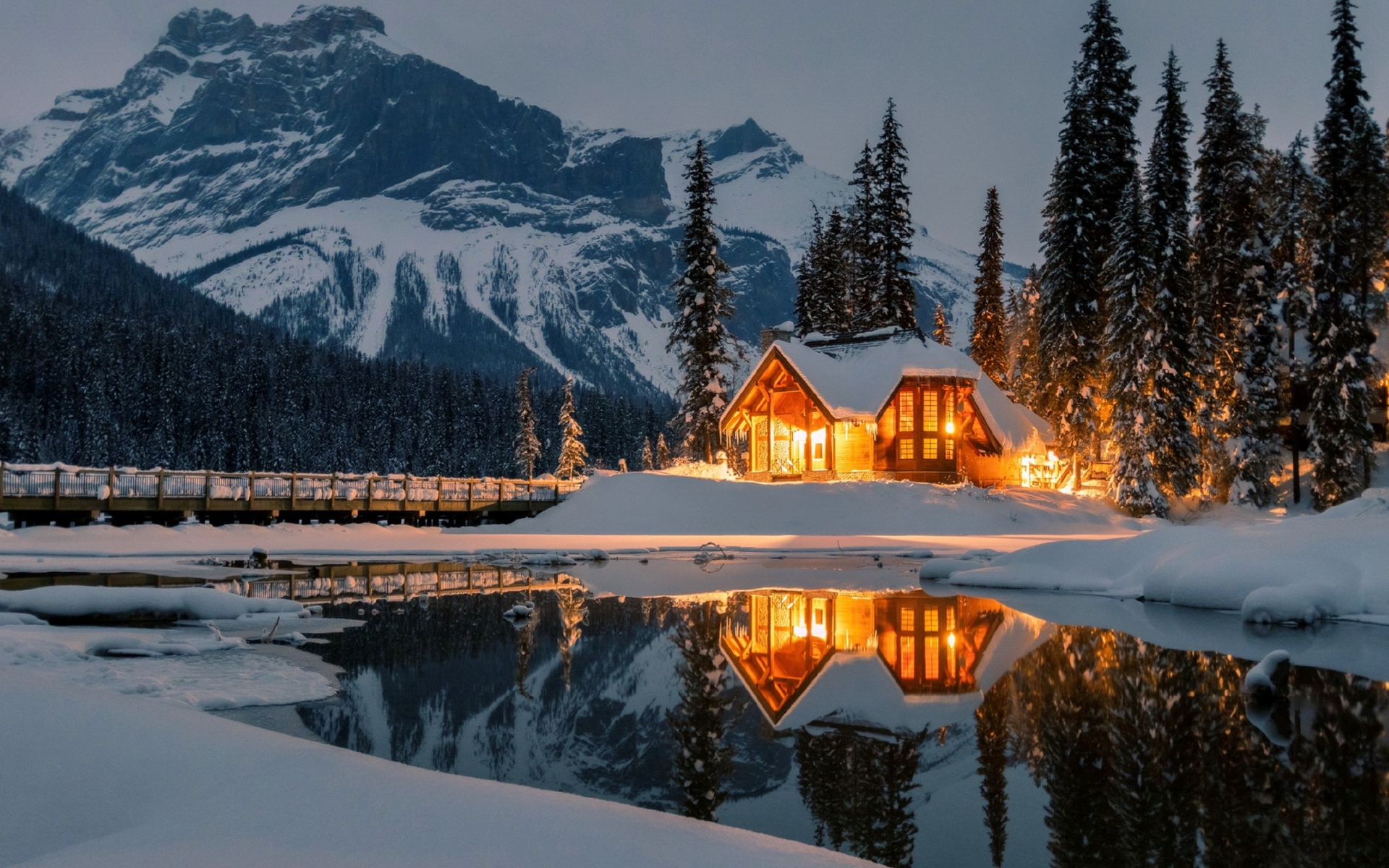 Дом на берегу горного озера зимой 