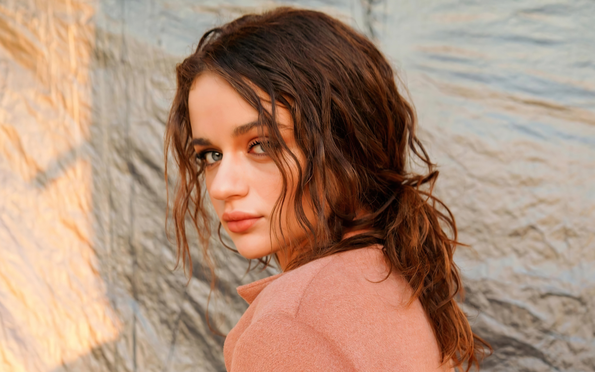 Актриса Джои Кинг стоит боком у стены 