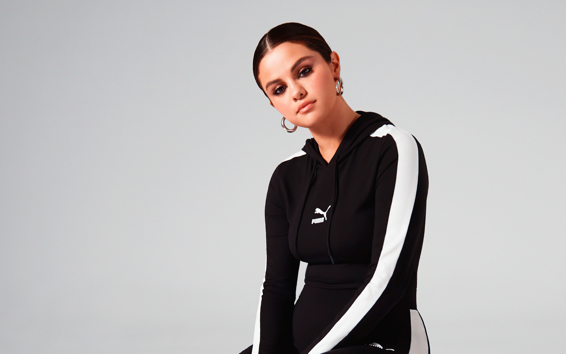 Актриса, модель Селена Гомес в спортивном костюме на сером фоне