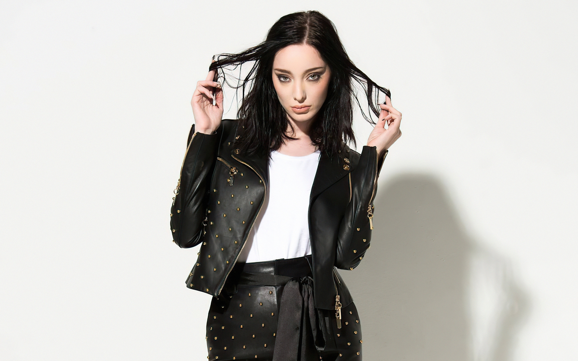 Американская актриса Эмма Дюмон в черном кожаном костюме на белом фоне