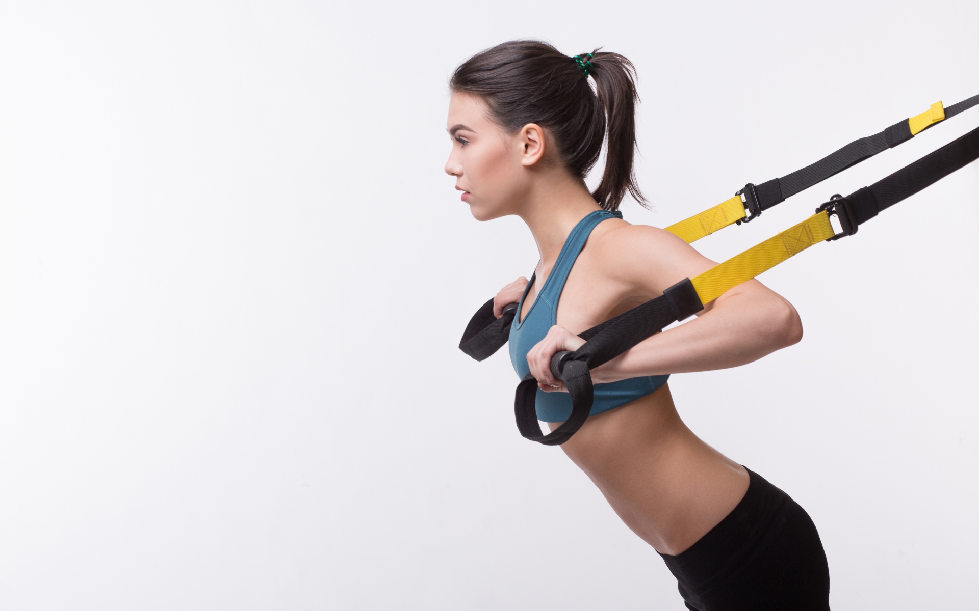 Спортивная девушка занимается в спортзале на белом фоне 