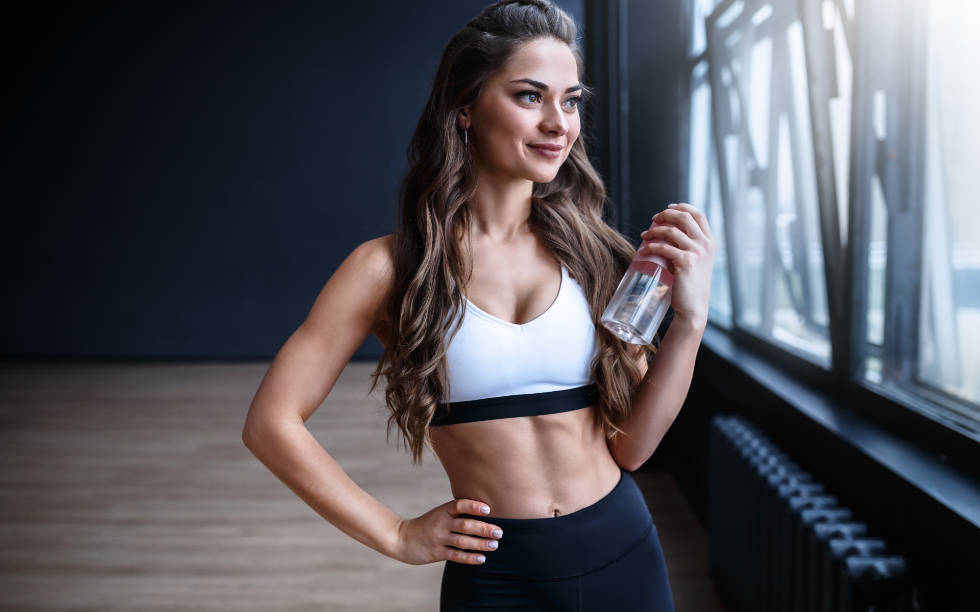 Beautiful athletic girl with a bottle of water in hand