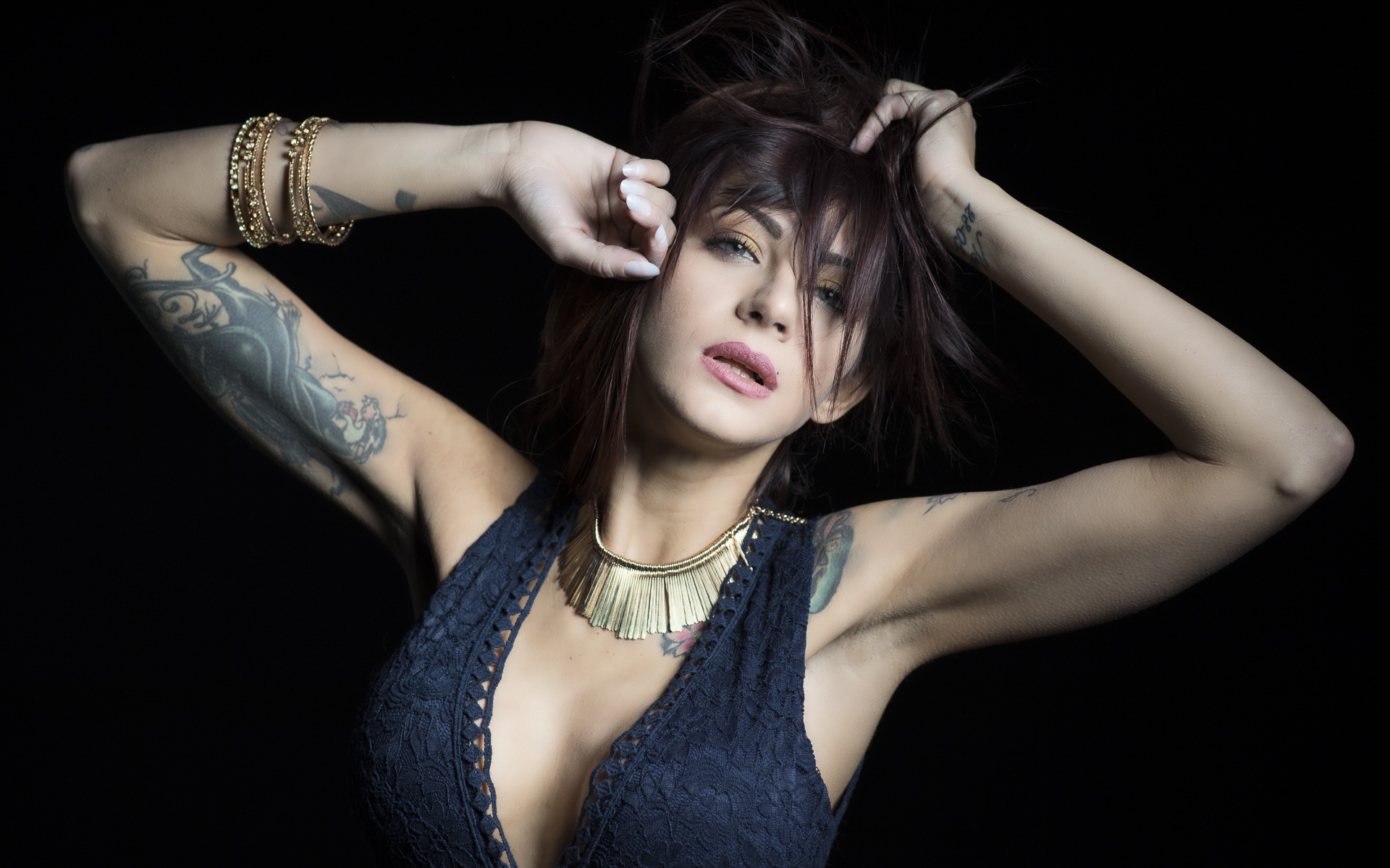 Красивая девушка в черном платье с татуировками на теле 