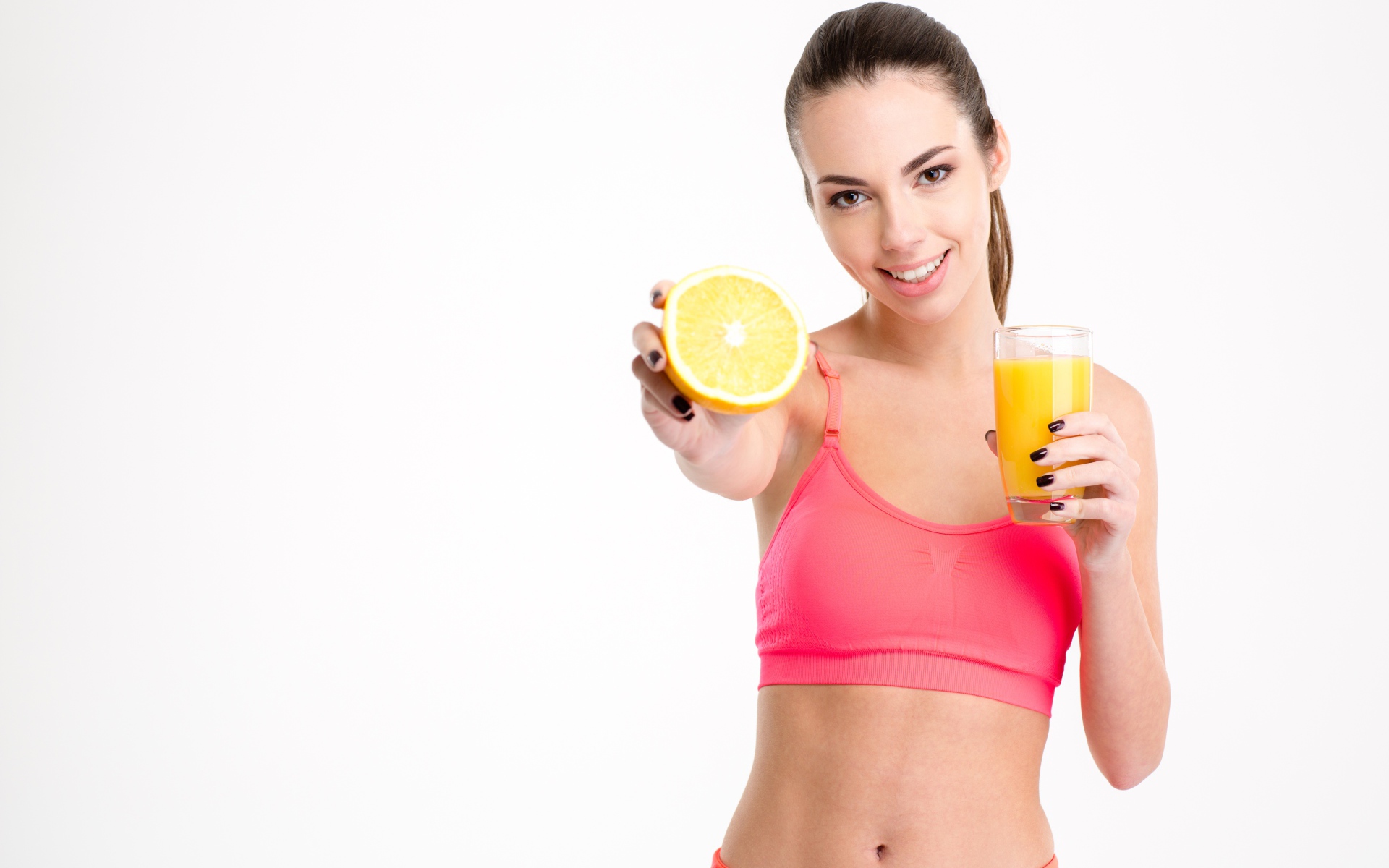 Девушка со стаканом сока и апельсином на белом фоне