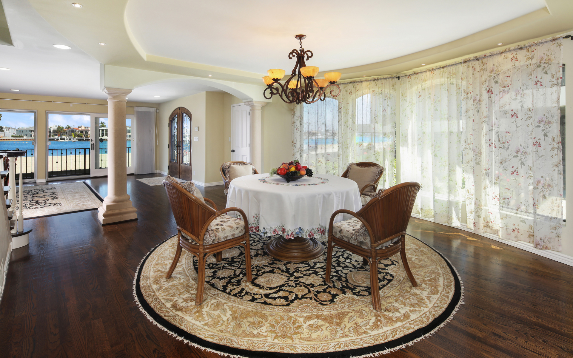 Большая гостиная комната с большими окнами и столом 