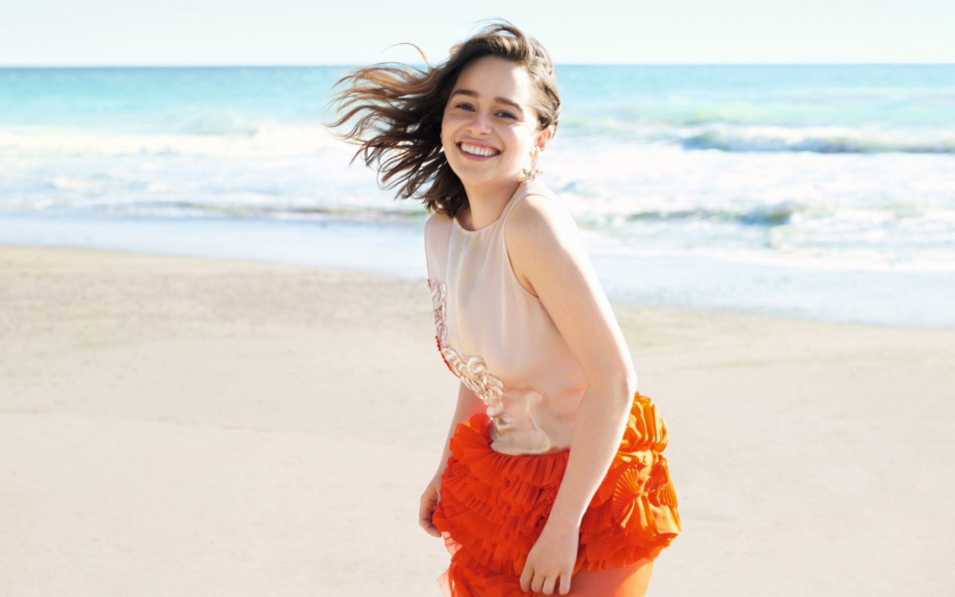 Улыбающаяся девушка, актриса Эмилия Кларк на фоне моря