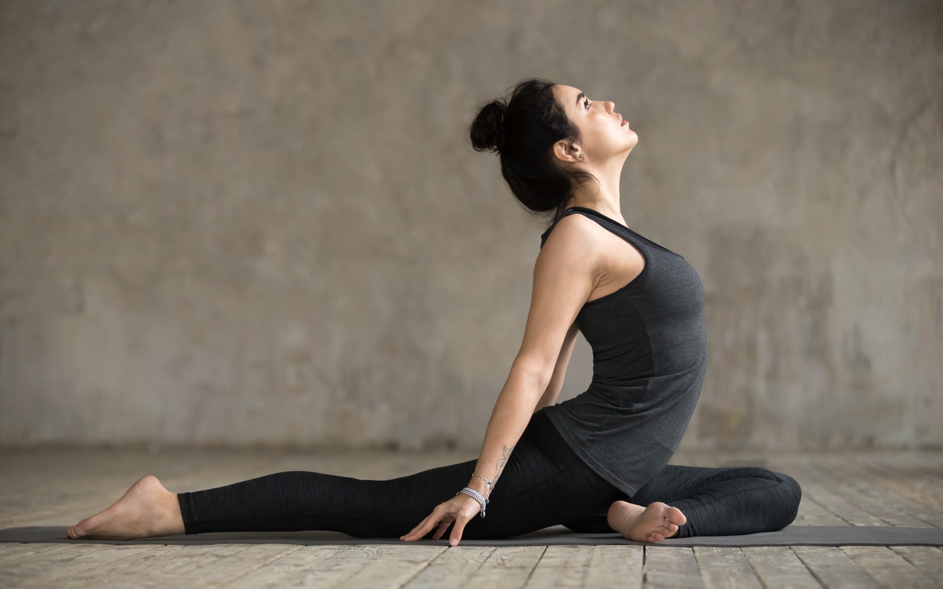 Спортивная девушка делает растяжку на полу 