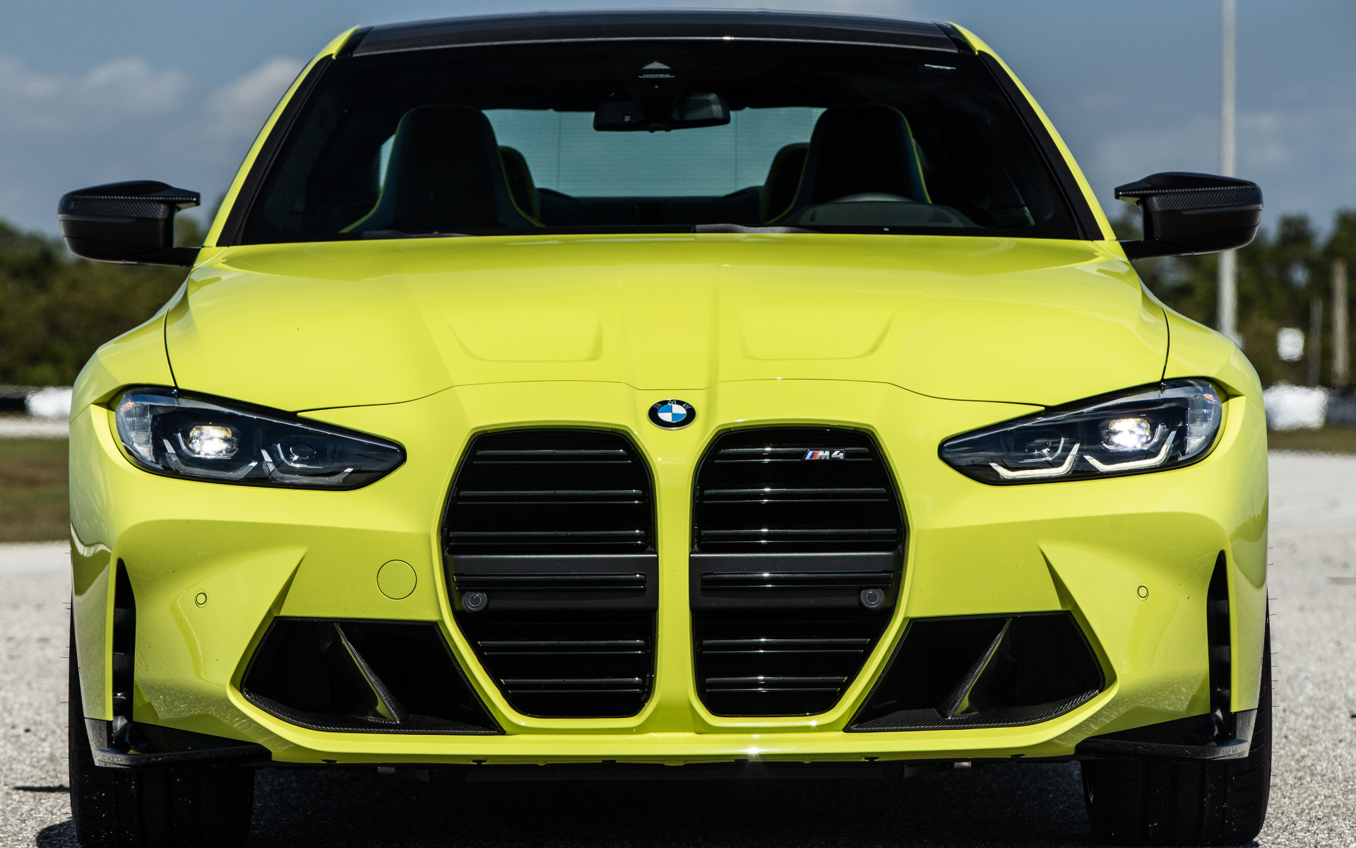 Желтый автомобиль  BMW M4 Coupé 2021 года вид спереди