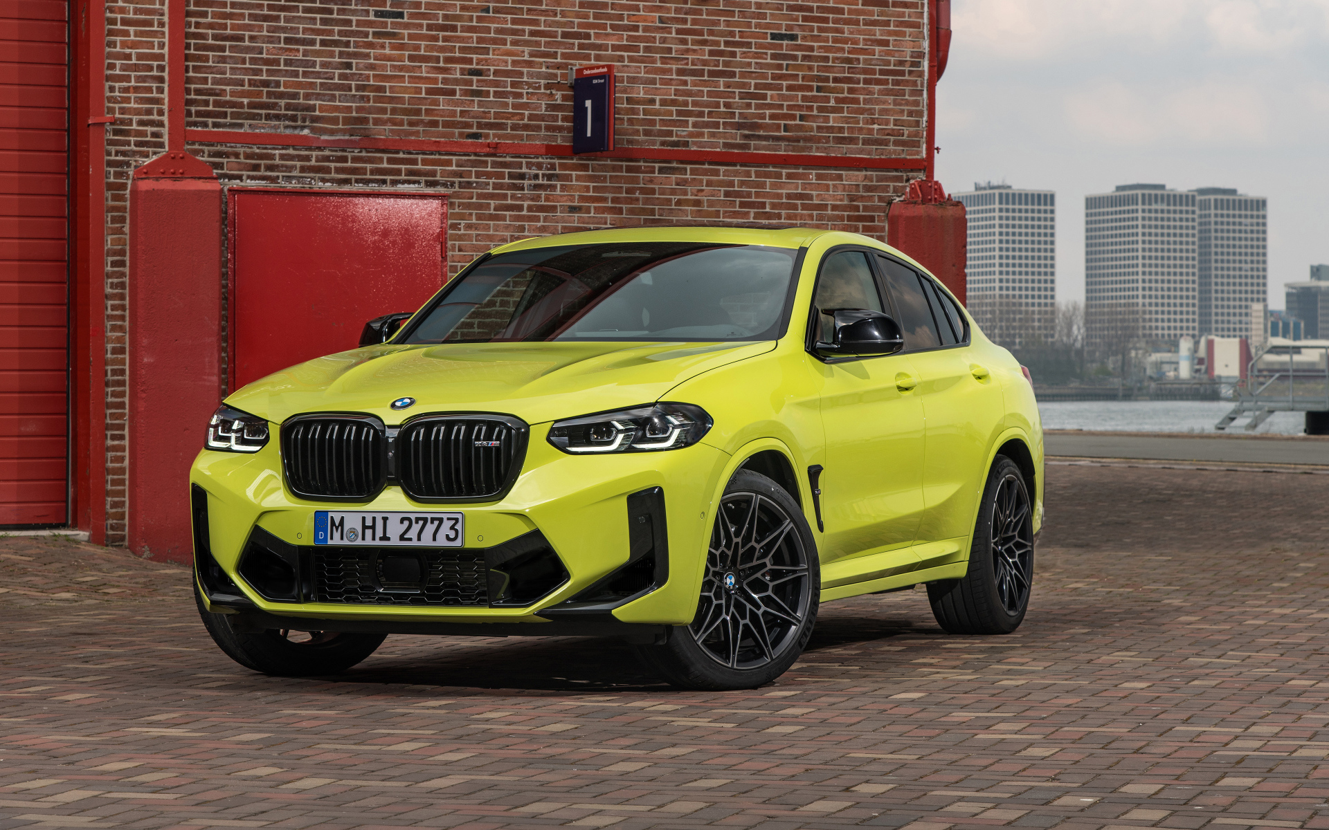 Желтый автомобиль BMW X4 M Competition 2021 года у стены