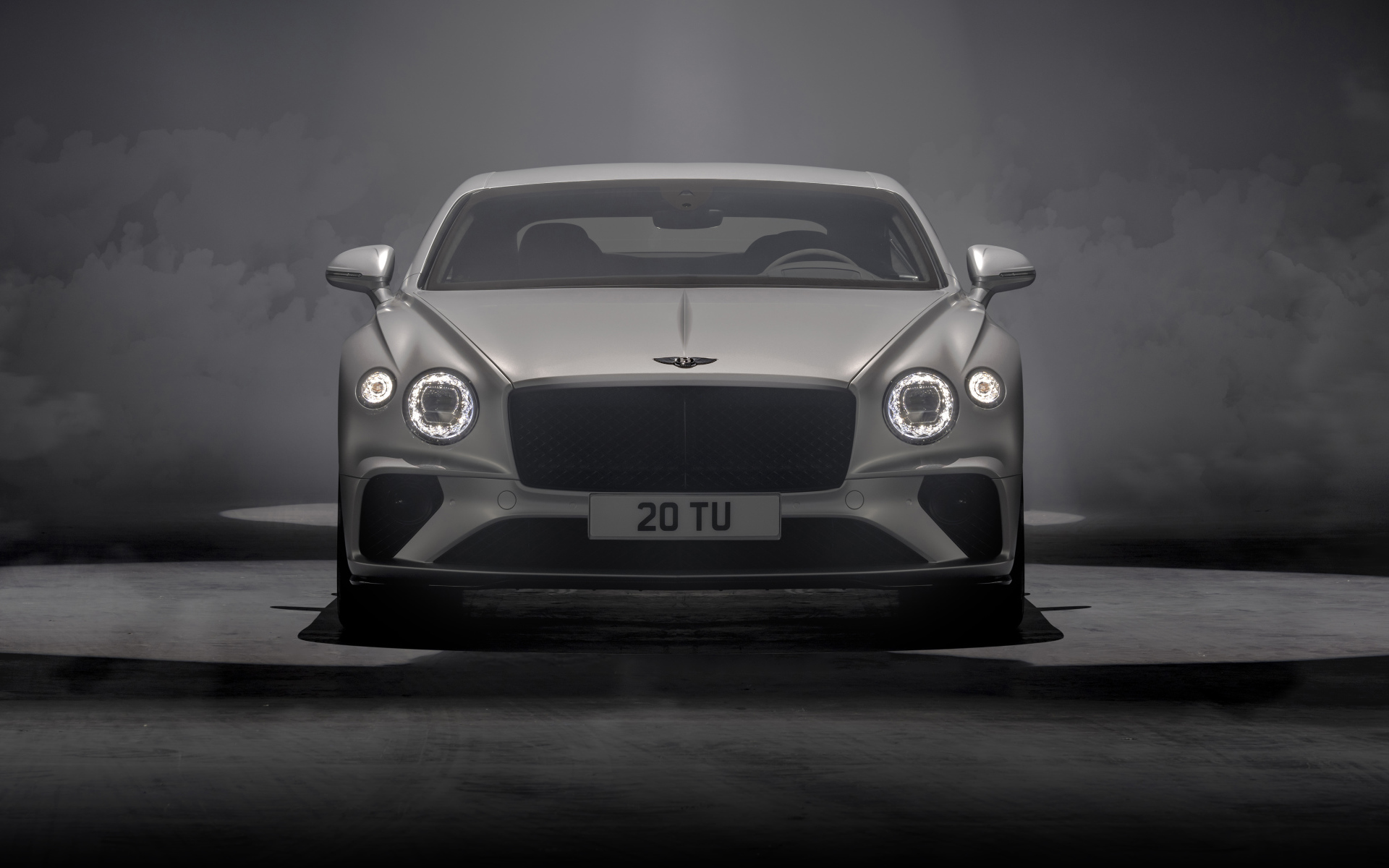 Серебристый автомобиль Bentley Continental GT Speed 2021 года на сером фоне