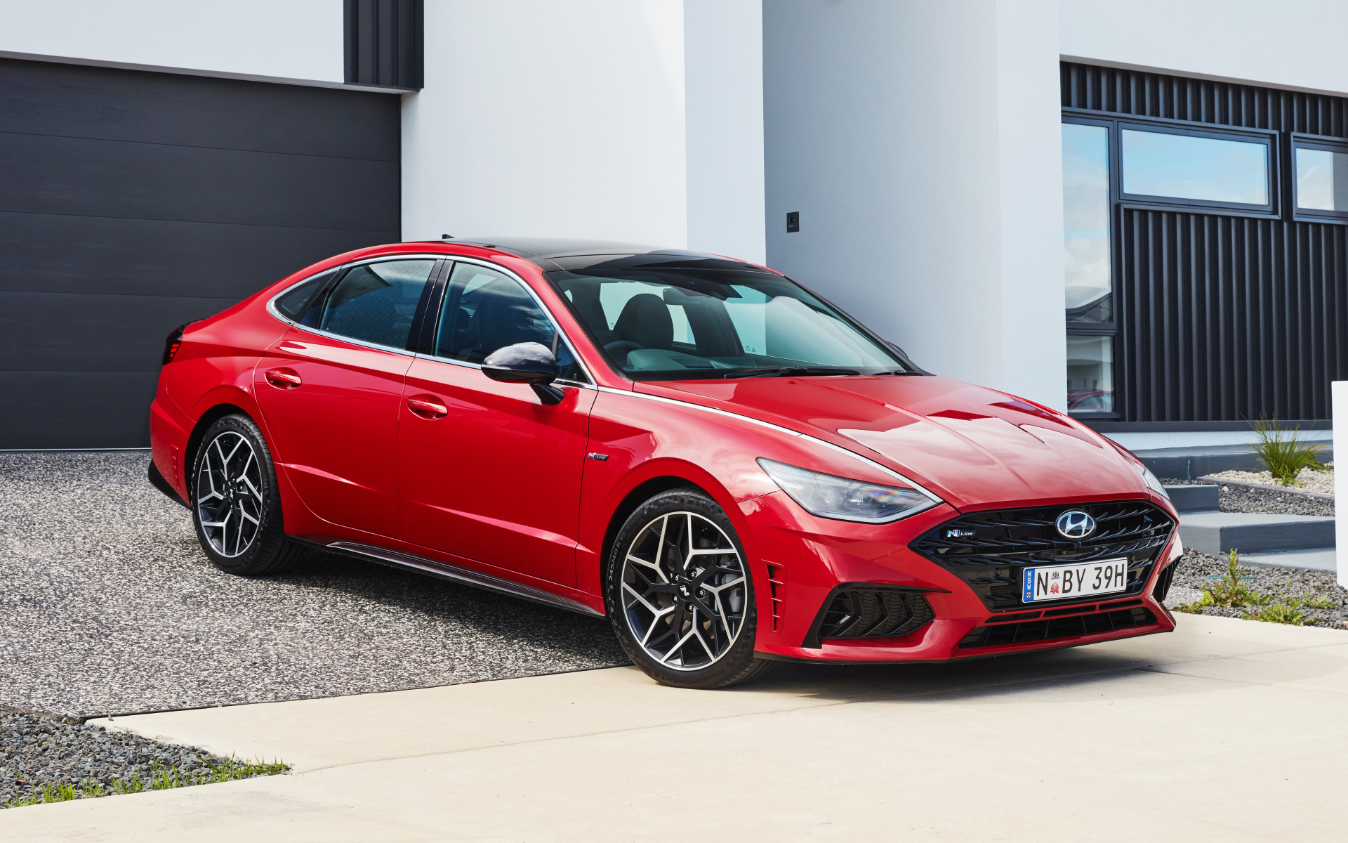 Красный автомобиль Hyundai Sonata N Line 2021 года у гаража