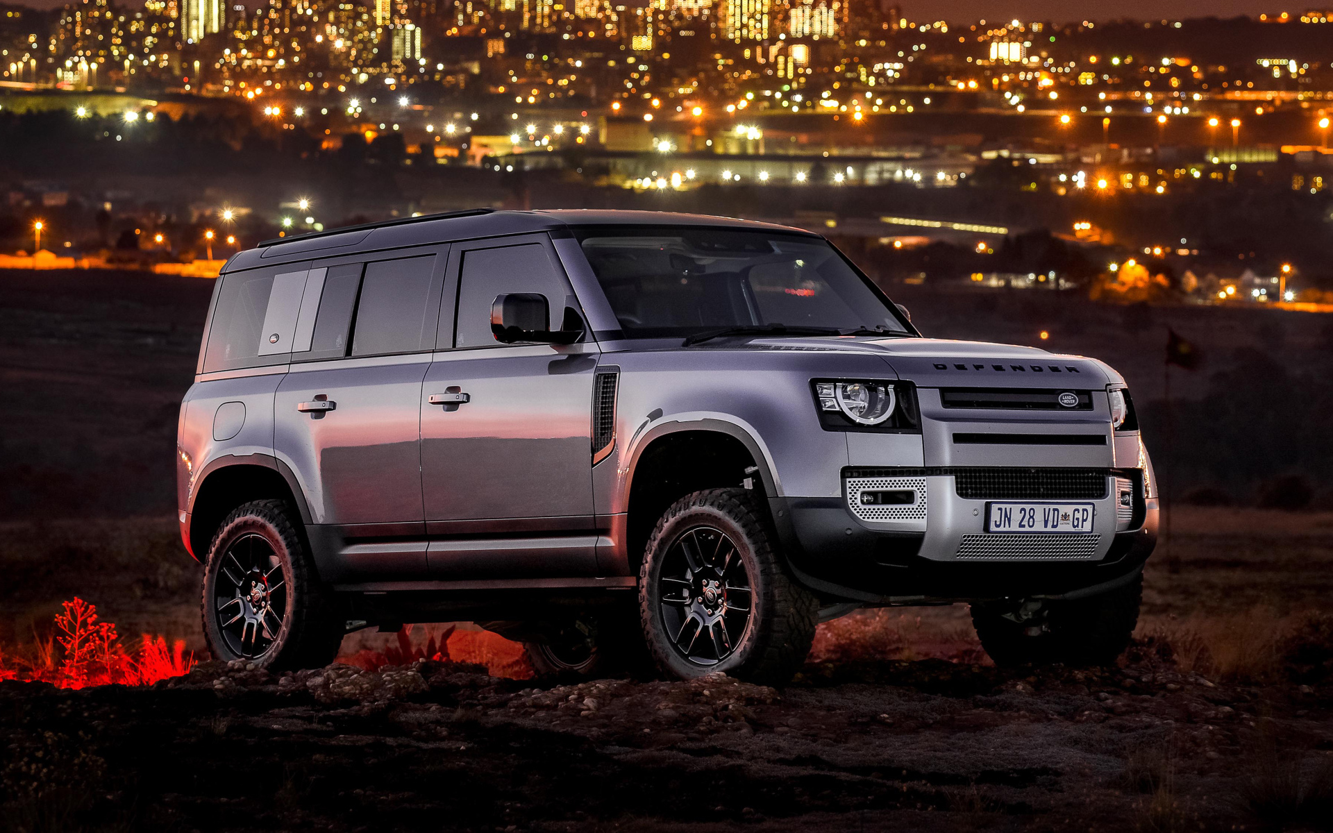 Серебристый внедорожник Land Rover Defender 110 P400 S Urban Pack 2021 года на фоне города