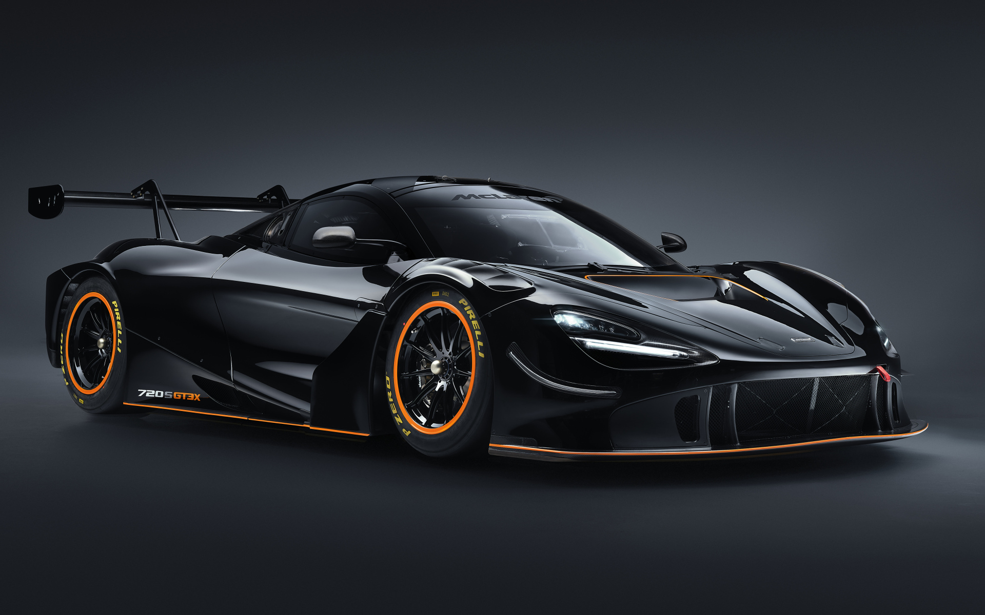 Черный спортивный автомобиль McLaren 720S GT3X 2021 года на сером фоне