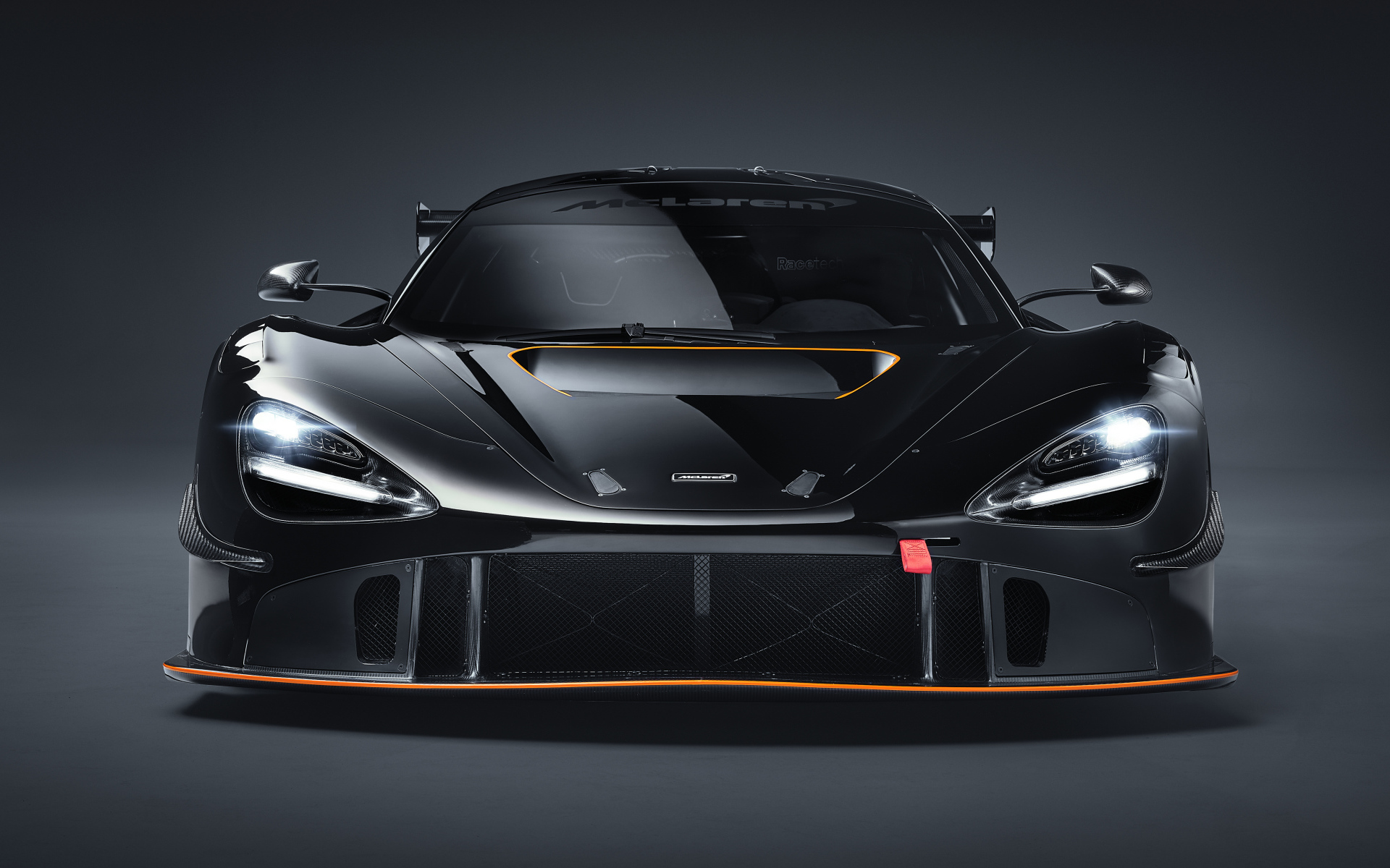 Автомобиль McLaren 720S GT3X 2021 года вид спереди на сером фоне