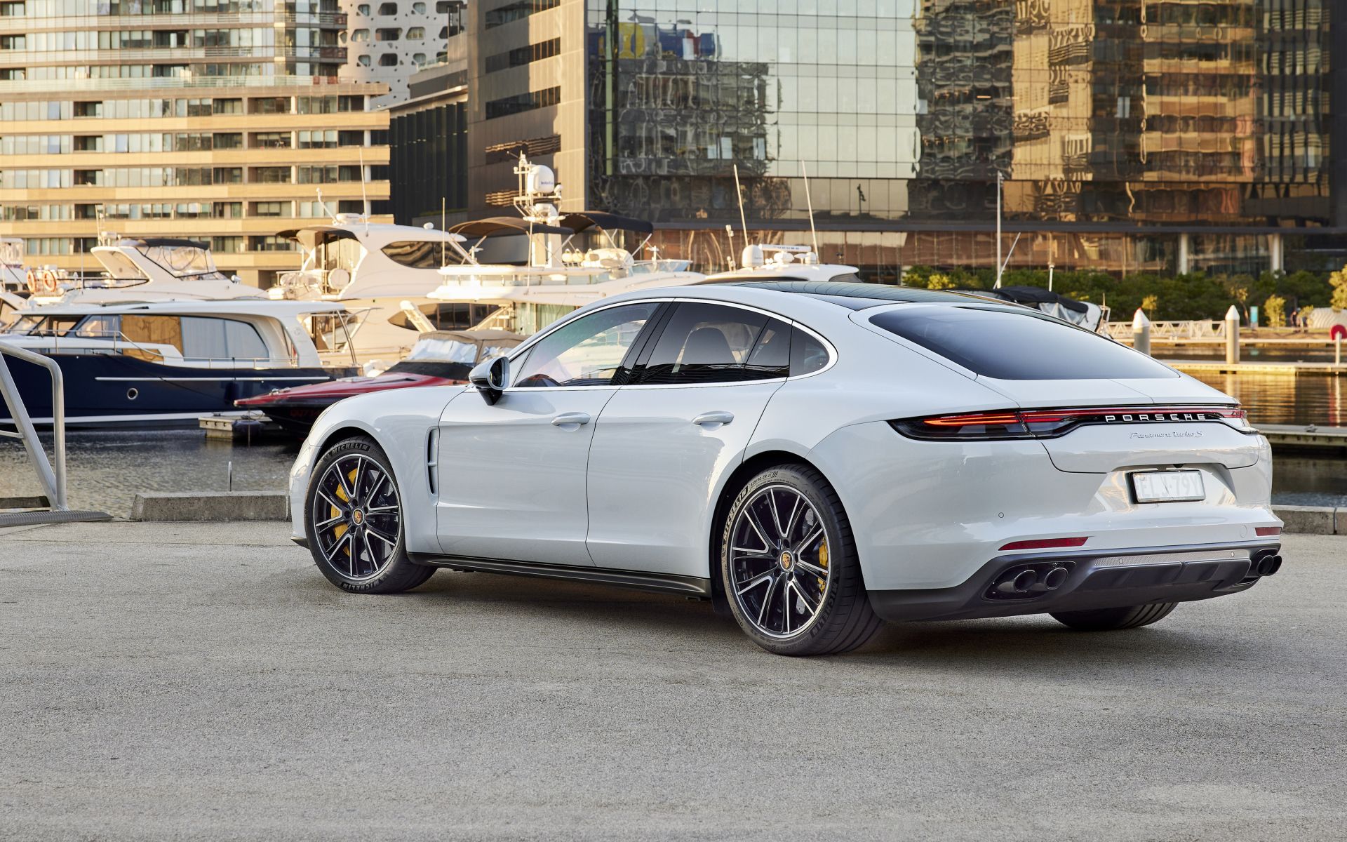 Белый автомобиль Porsche Panamera Turbo S 2021 года вид сзади