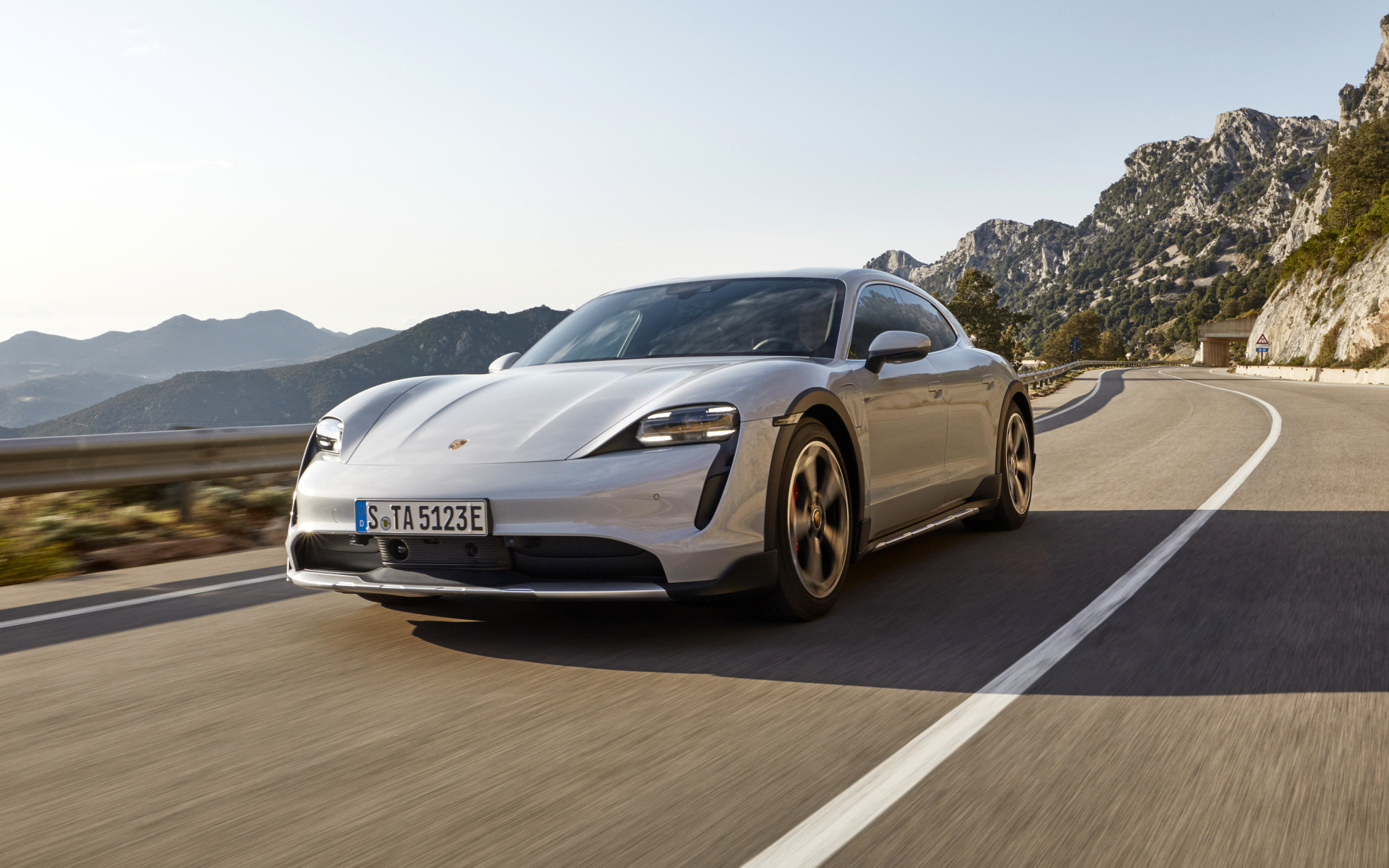 Автомобиль Porsche Taycan 4S Cross Turismo 2021 года на трассе в горах
