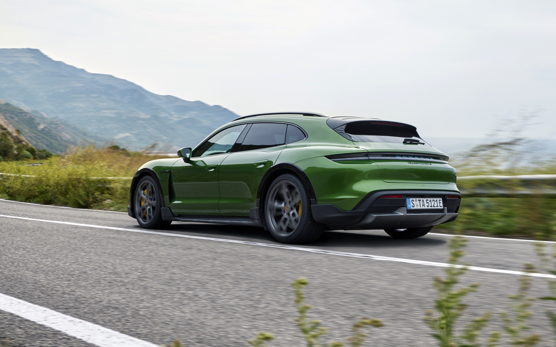 Зеленый автомобиль Porsche Taycan Turbo S Cross Turismo 2021 года вид сзади