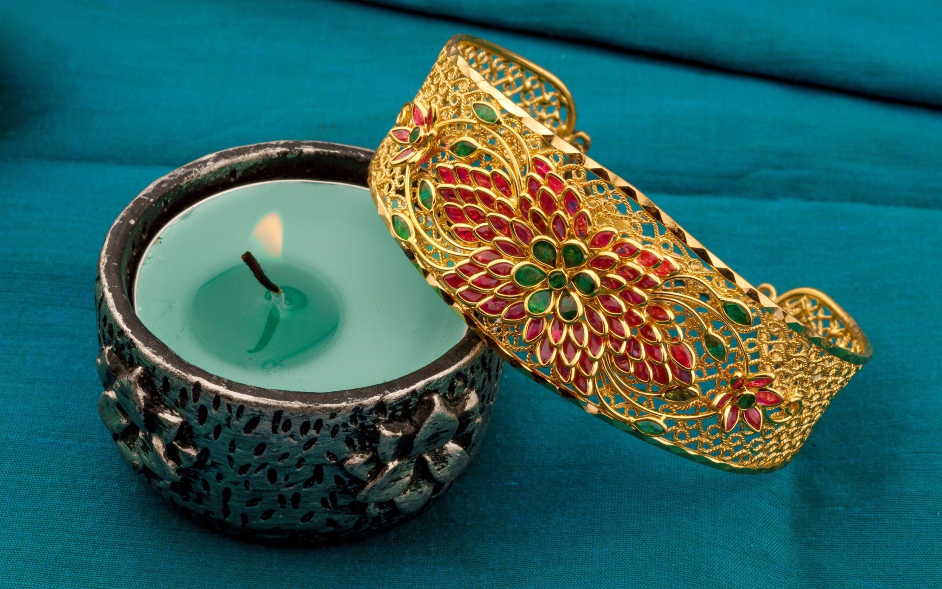 Красивый браслет со свечой на синем покрывале 