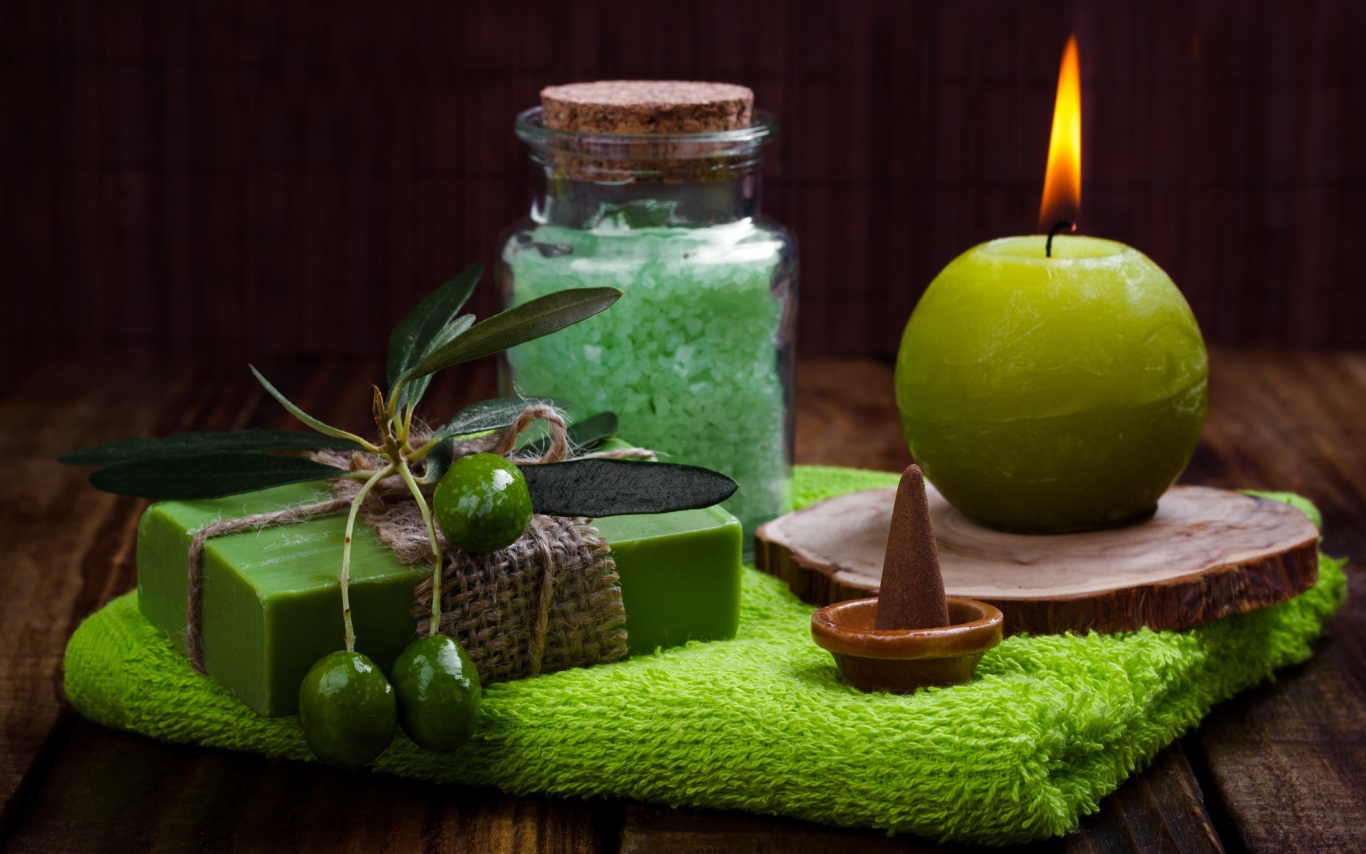 Зажженная свеча и мыло с оливками  и солью 