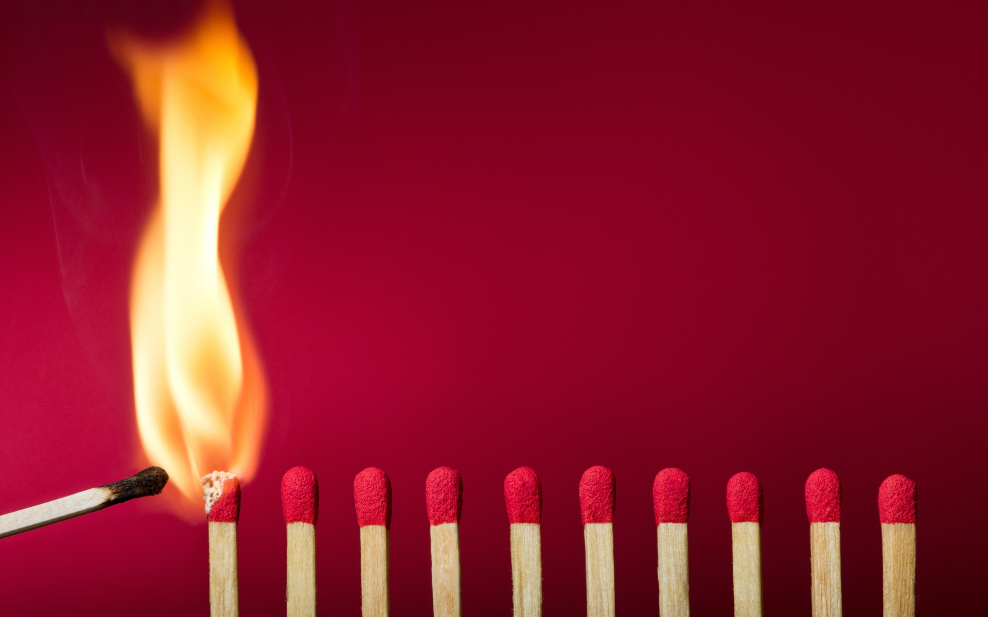 Спички поджигают на красном фоне