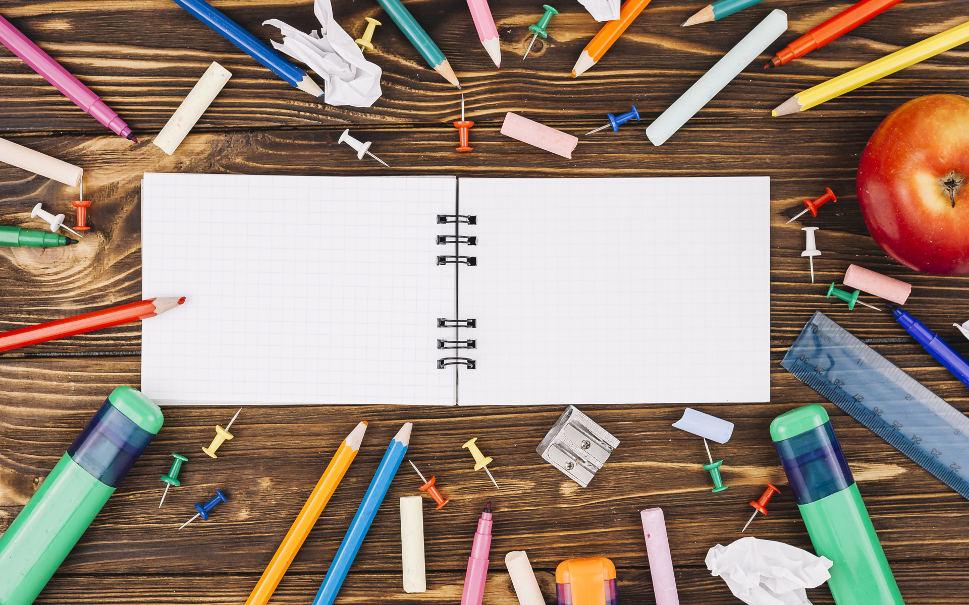 Открытый блокнот с ручками  на столе 