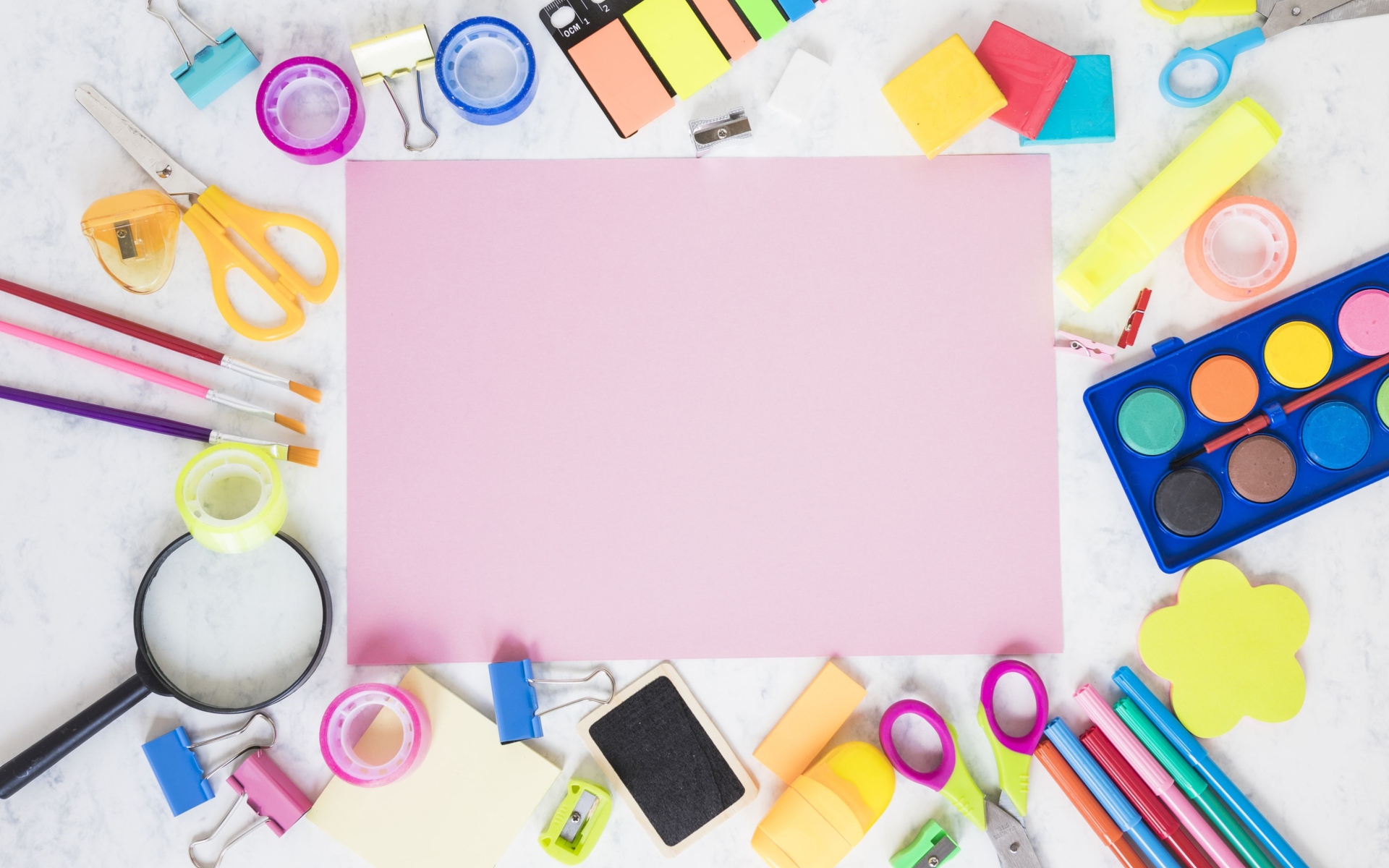 Лист бумаги, краски и канцелярские предметы на столе 