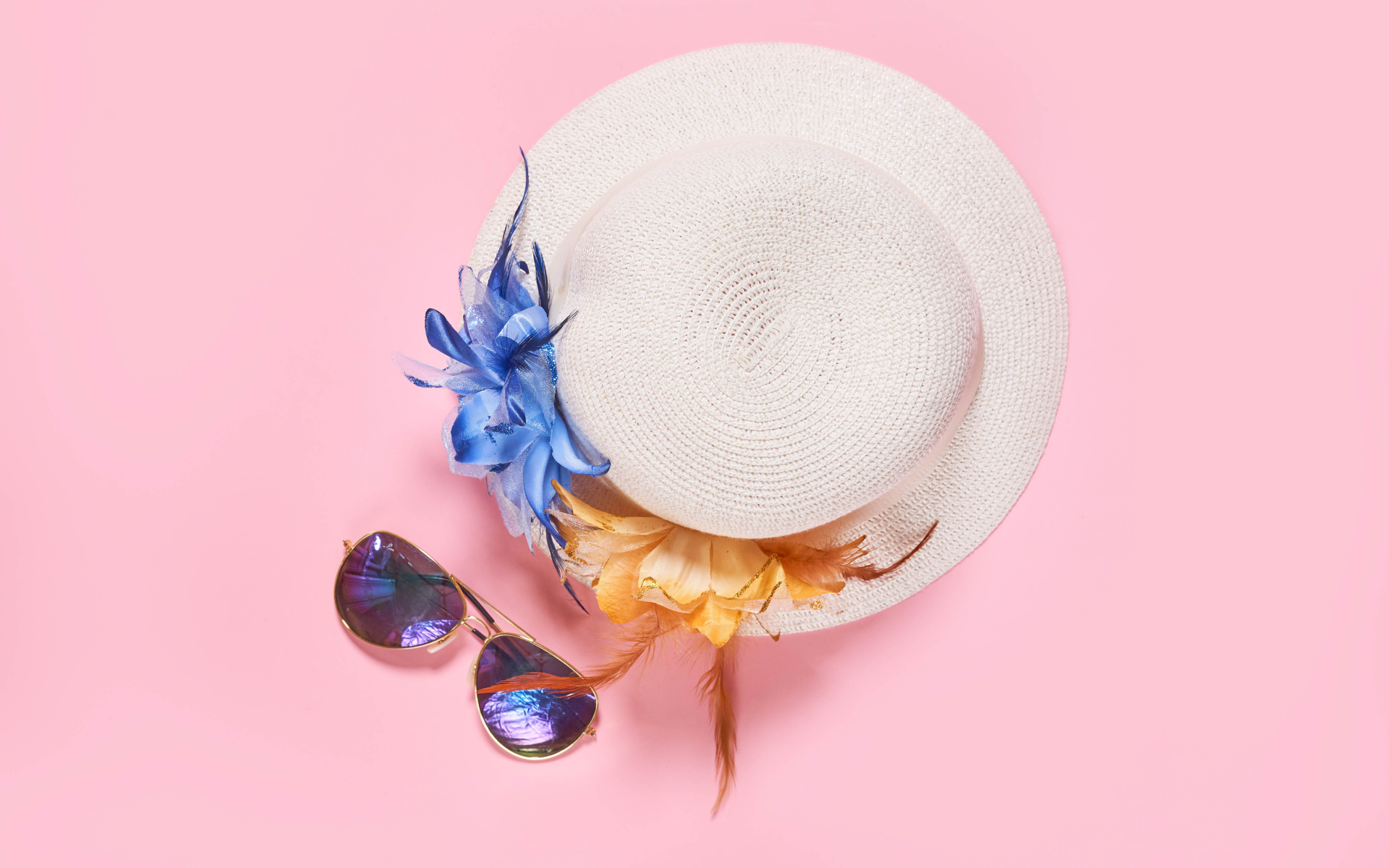 Straw hat with glasses on pink background