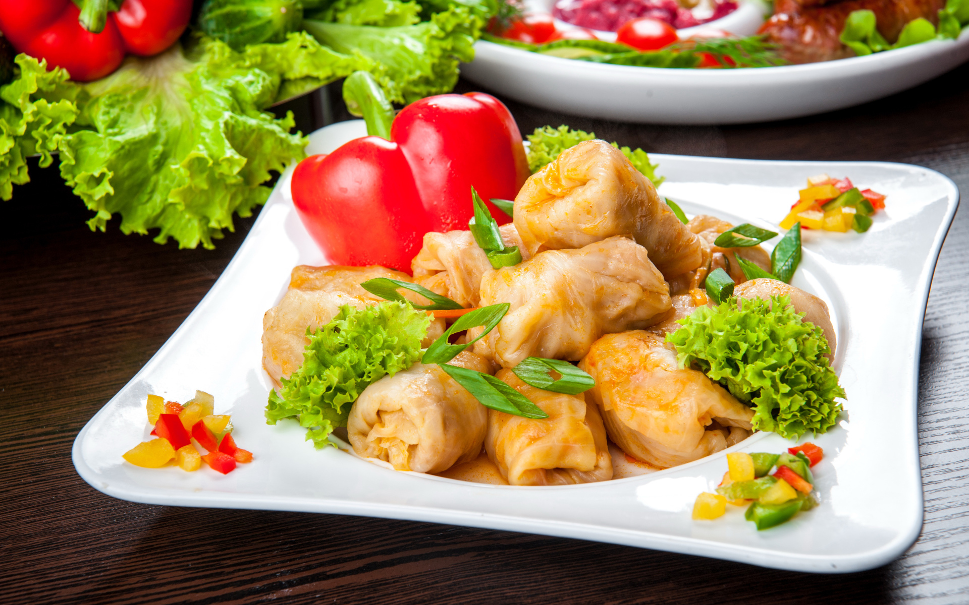 Аппетитные голубцы на тарелке с перцем 