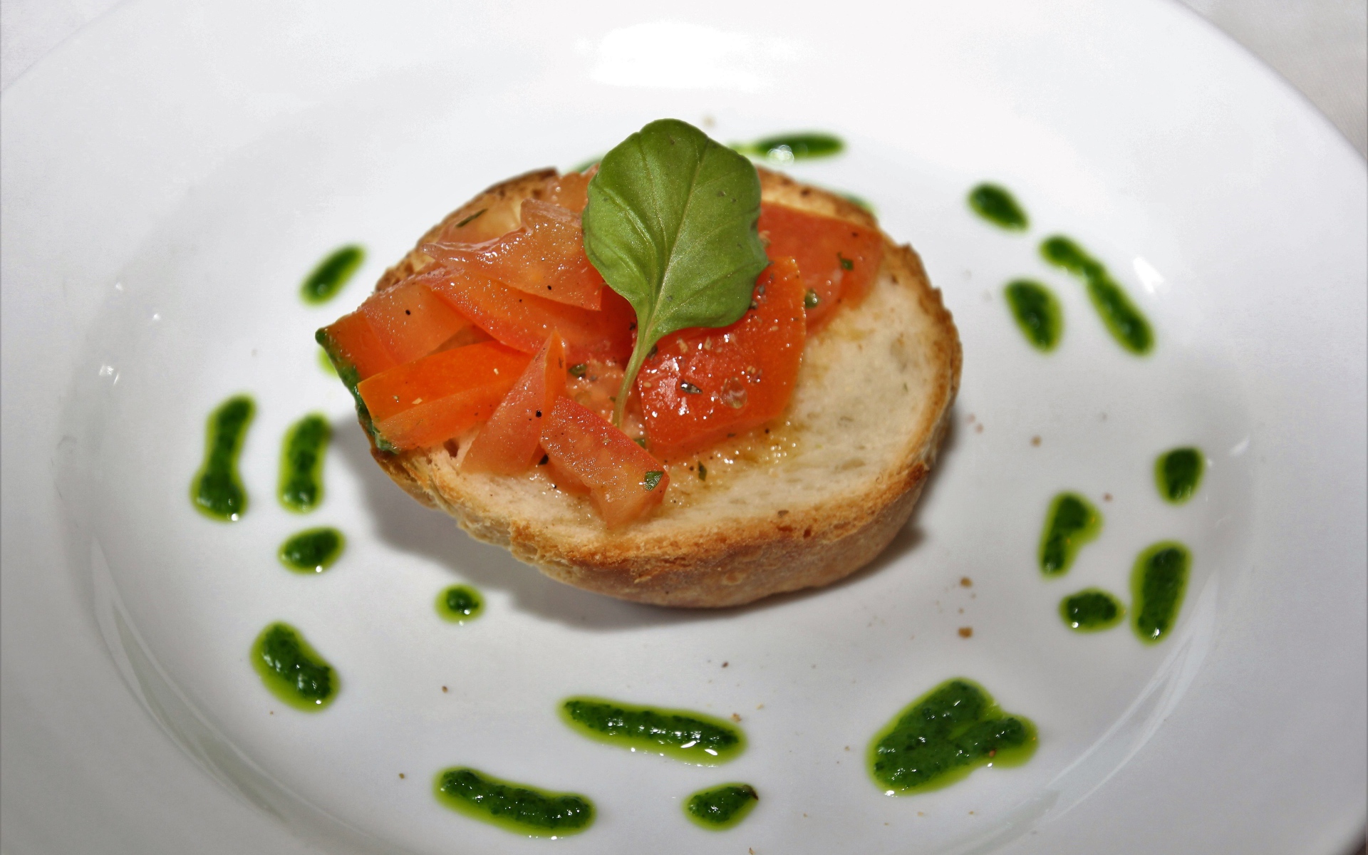 Брускетта на тарелке с помидорами и соусом