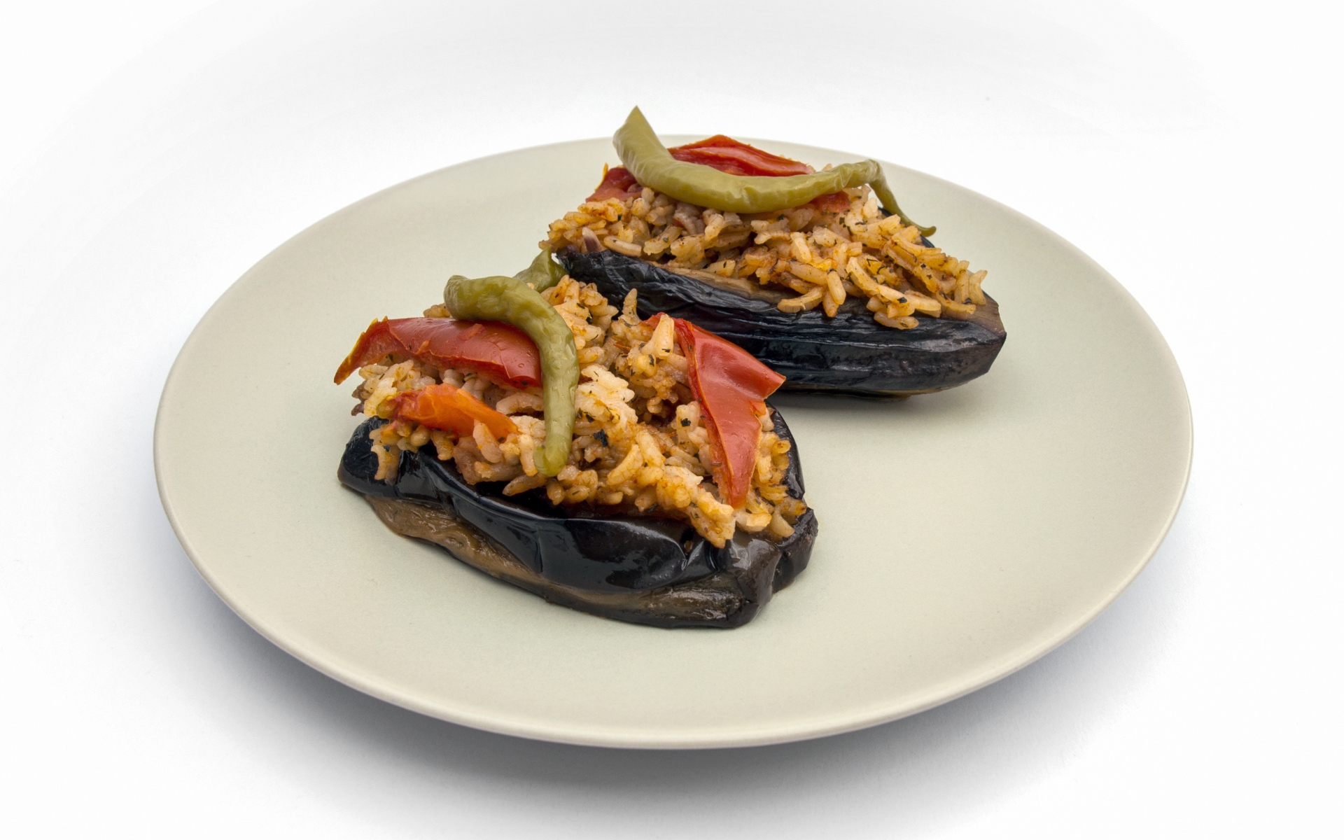 Блюдо из баклажанов с рисом на большой белой тарелке