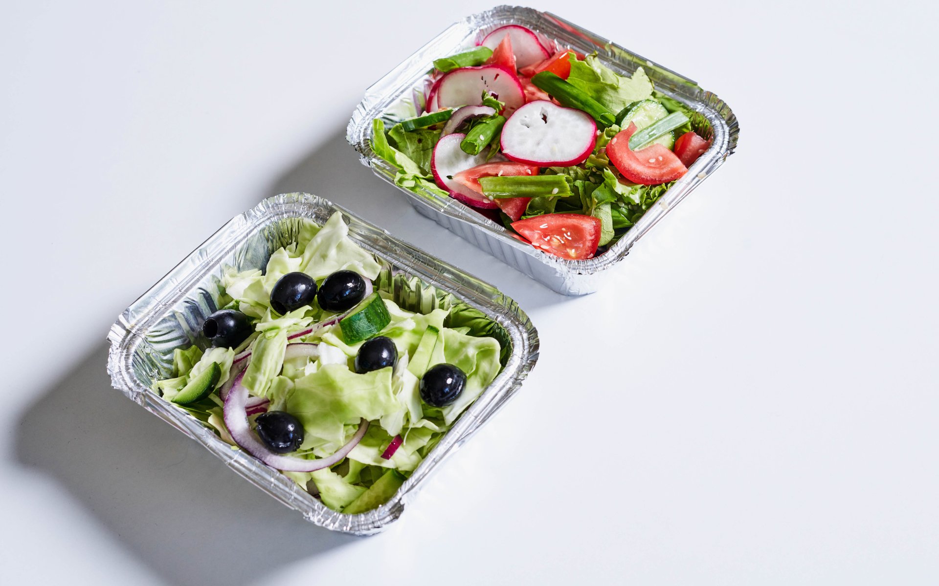 Салат из свежих овощей в тарелках на сером фоне 