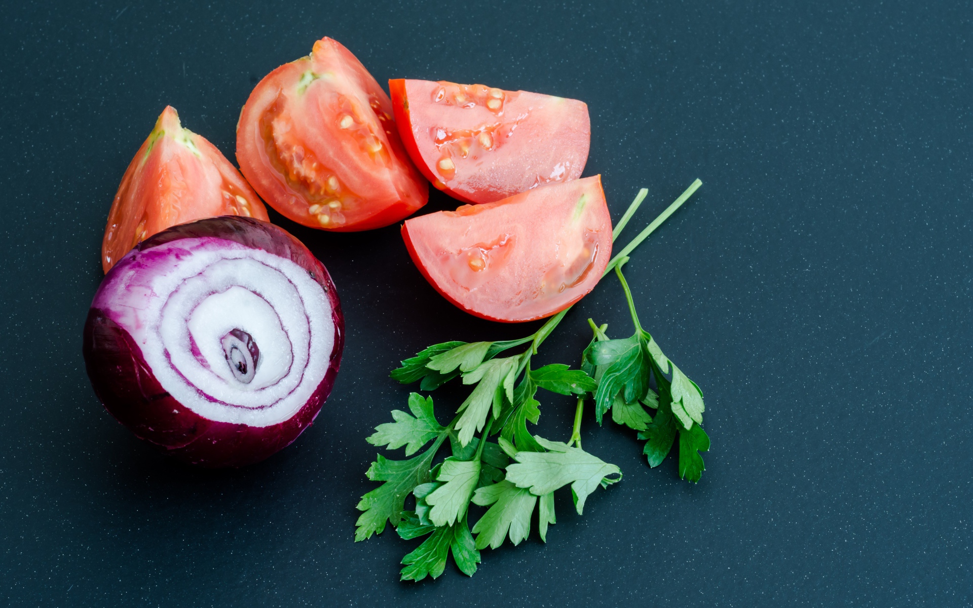 Лук, помидоры и петрушка на сером столе
