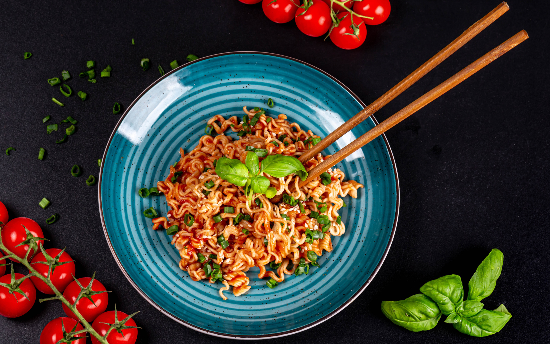 Макароны в соусе на столе с помидорами