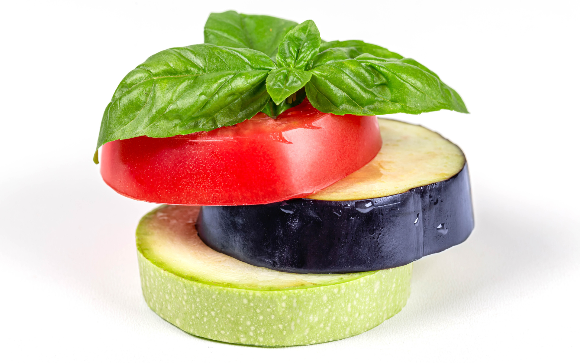 Кусок помидора, баклажана и кабачка на белом фоне