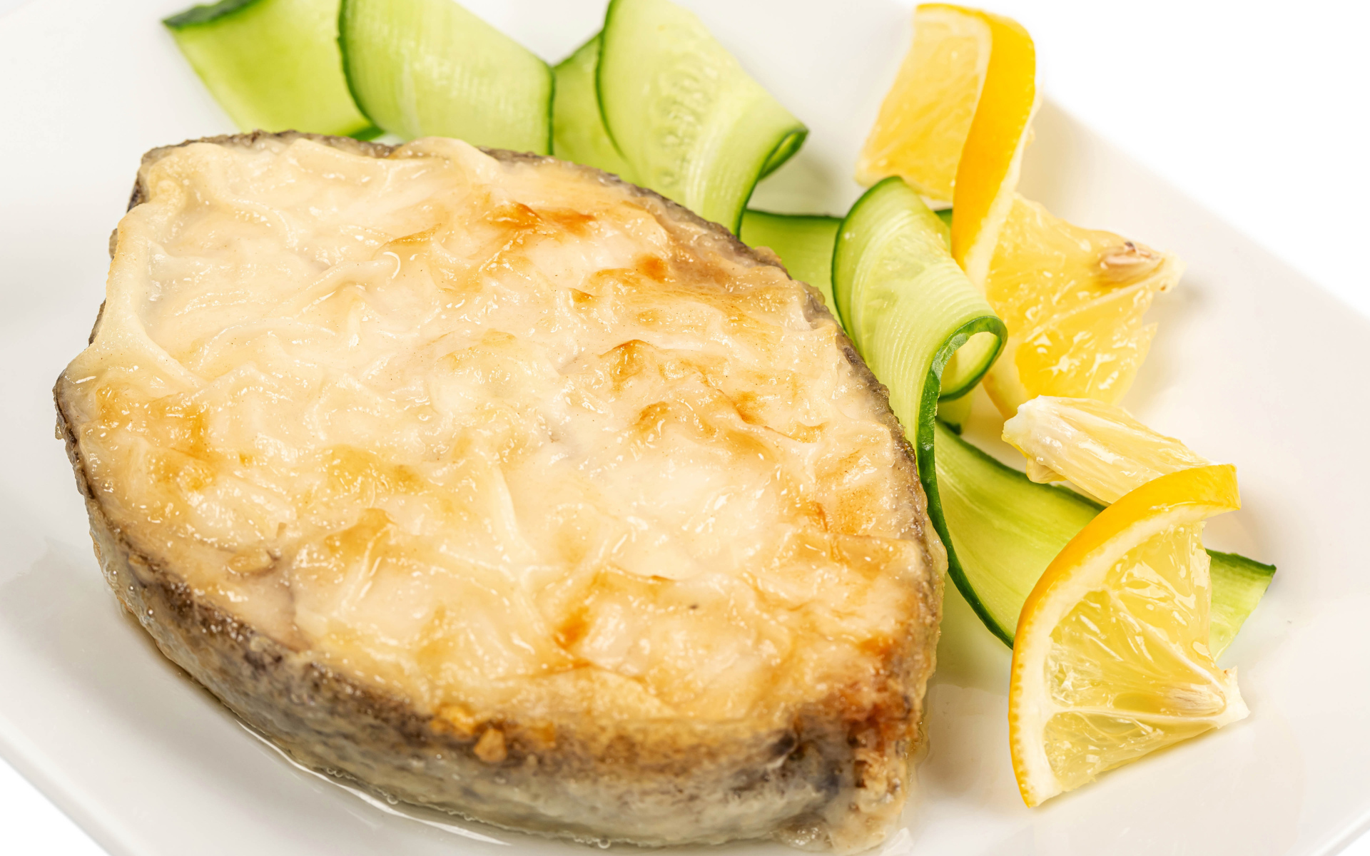 Картофель с сыром на тарелке с огурцами и лимоном 