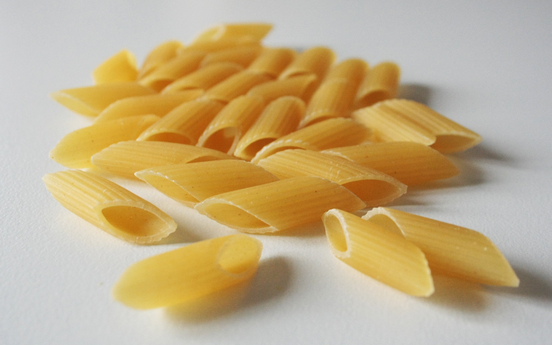 Сырые желтые макароны на сером фоне