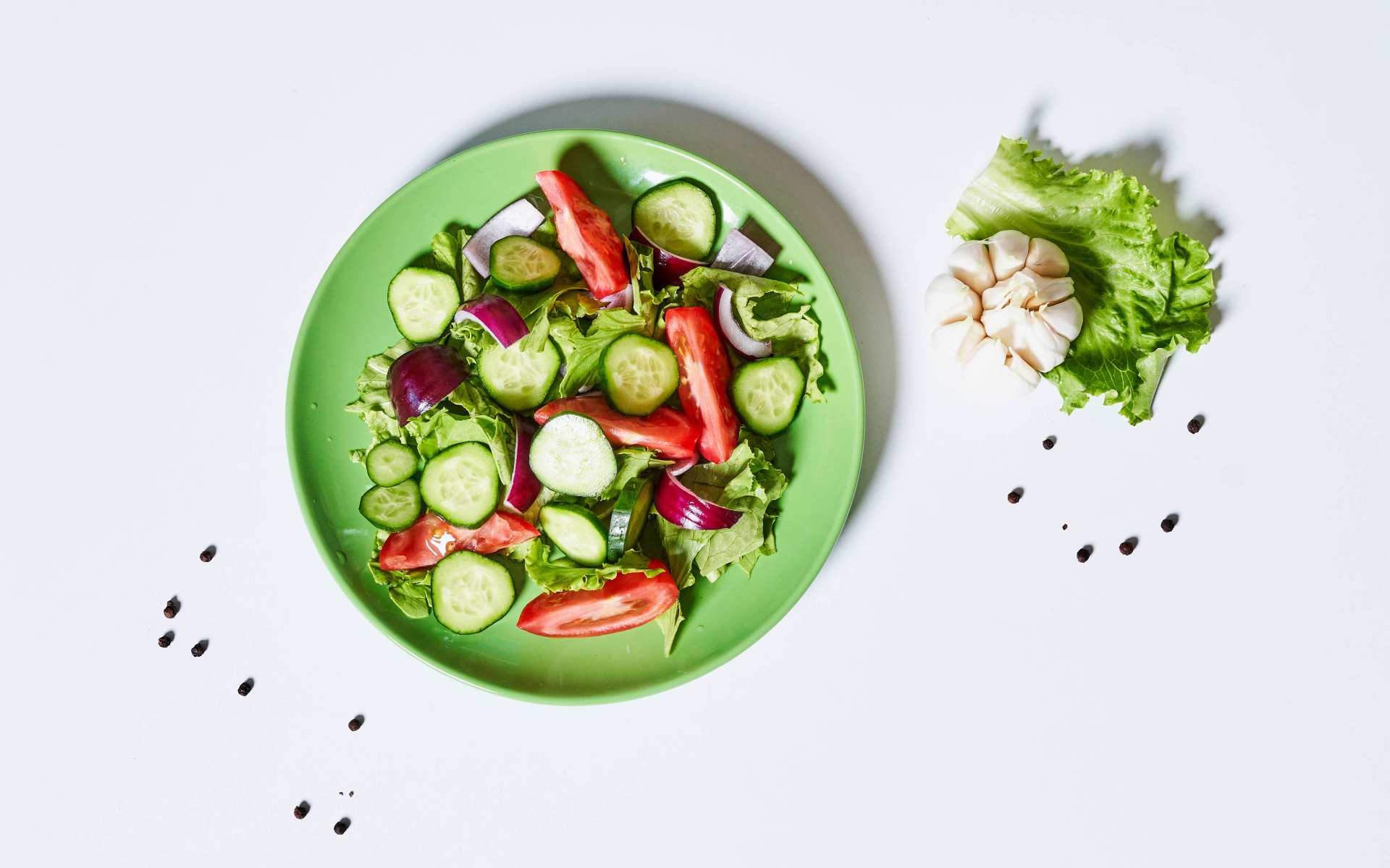 Салат с огурцами, луком, помидорами и листьями салата