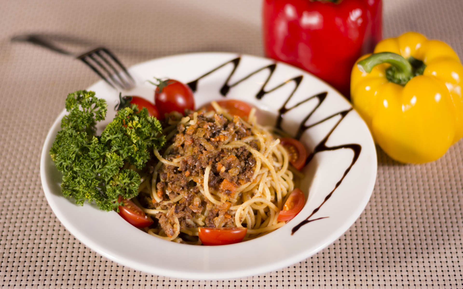 Спагетти с фаршем и помидорами в тарелке 