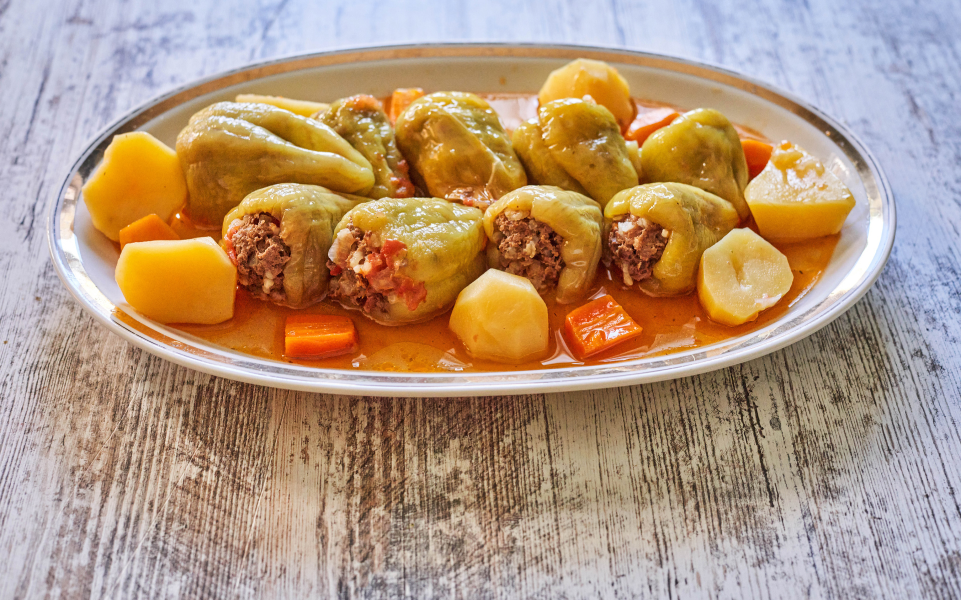 Фаршированный перец на тарелке с картофелем