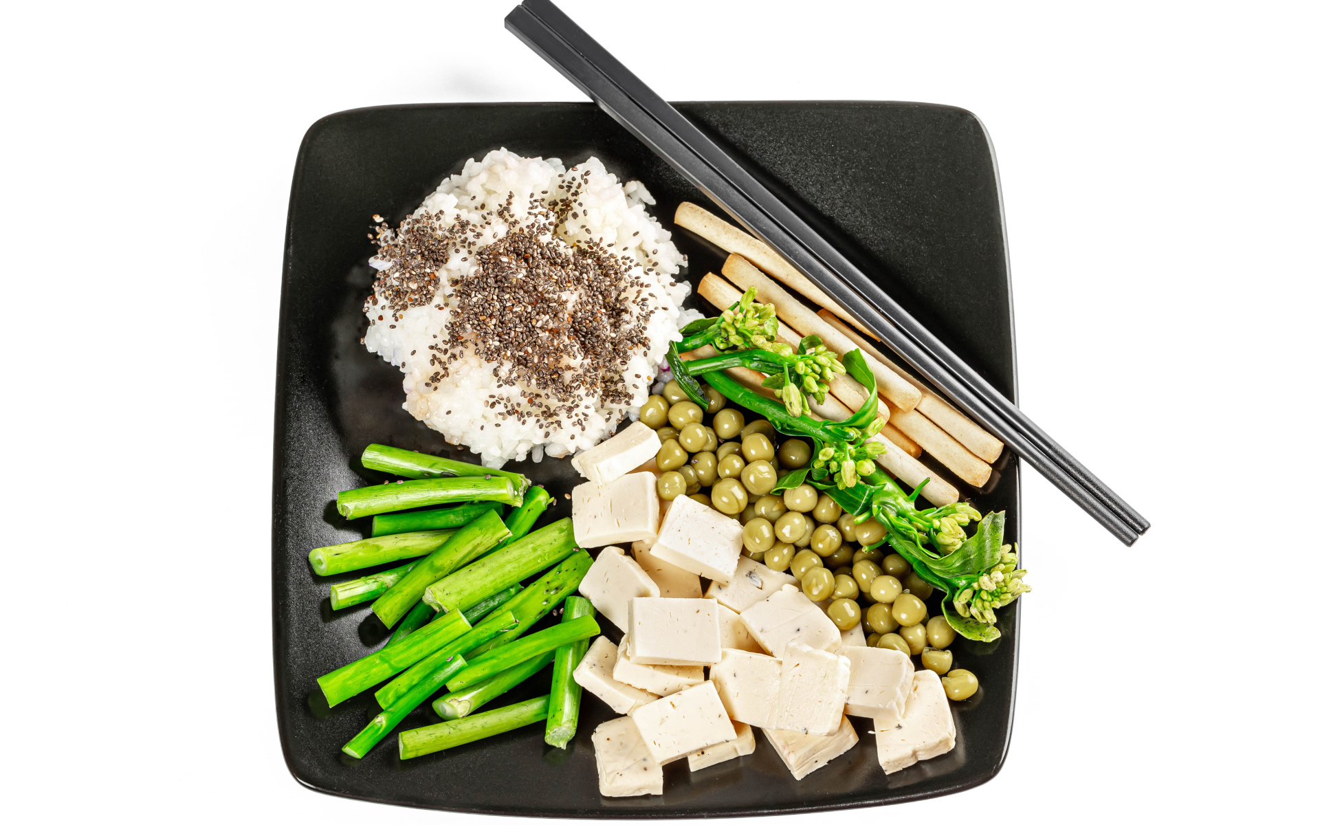 Овощи, сыр и рис на тарелке с палочками