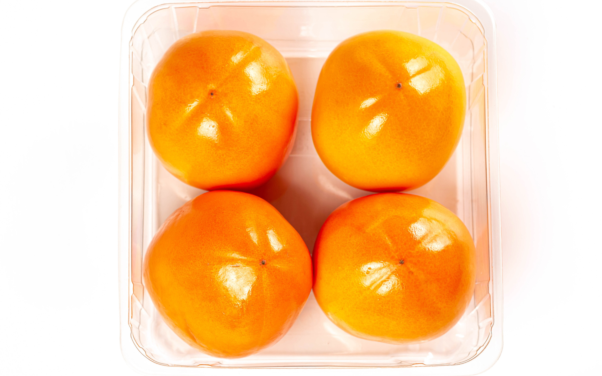 Спелая хурма с лотке на белом фоне