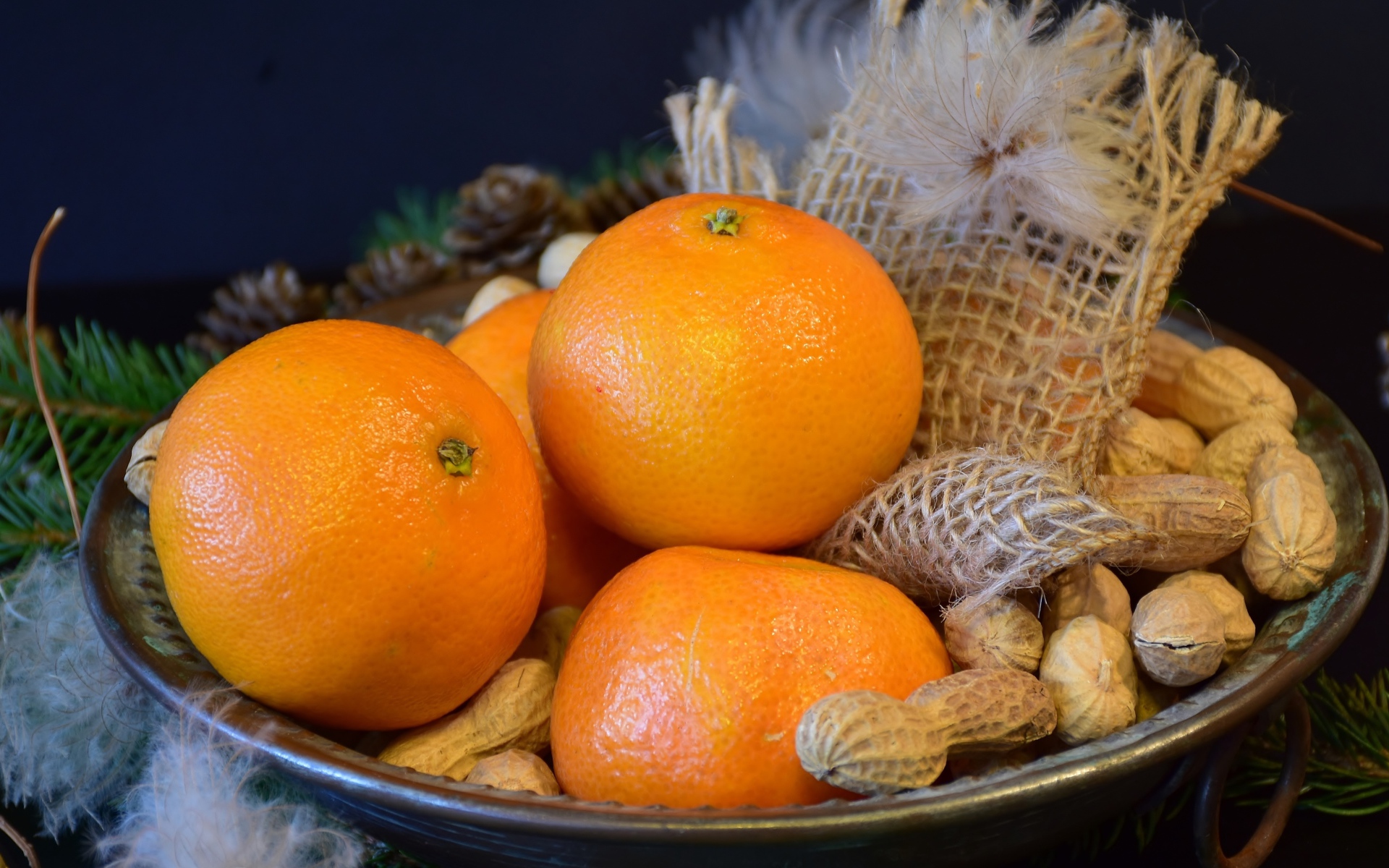 Желтые апельсины с арахисом  на тарелке