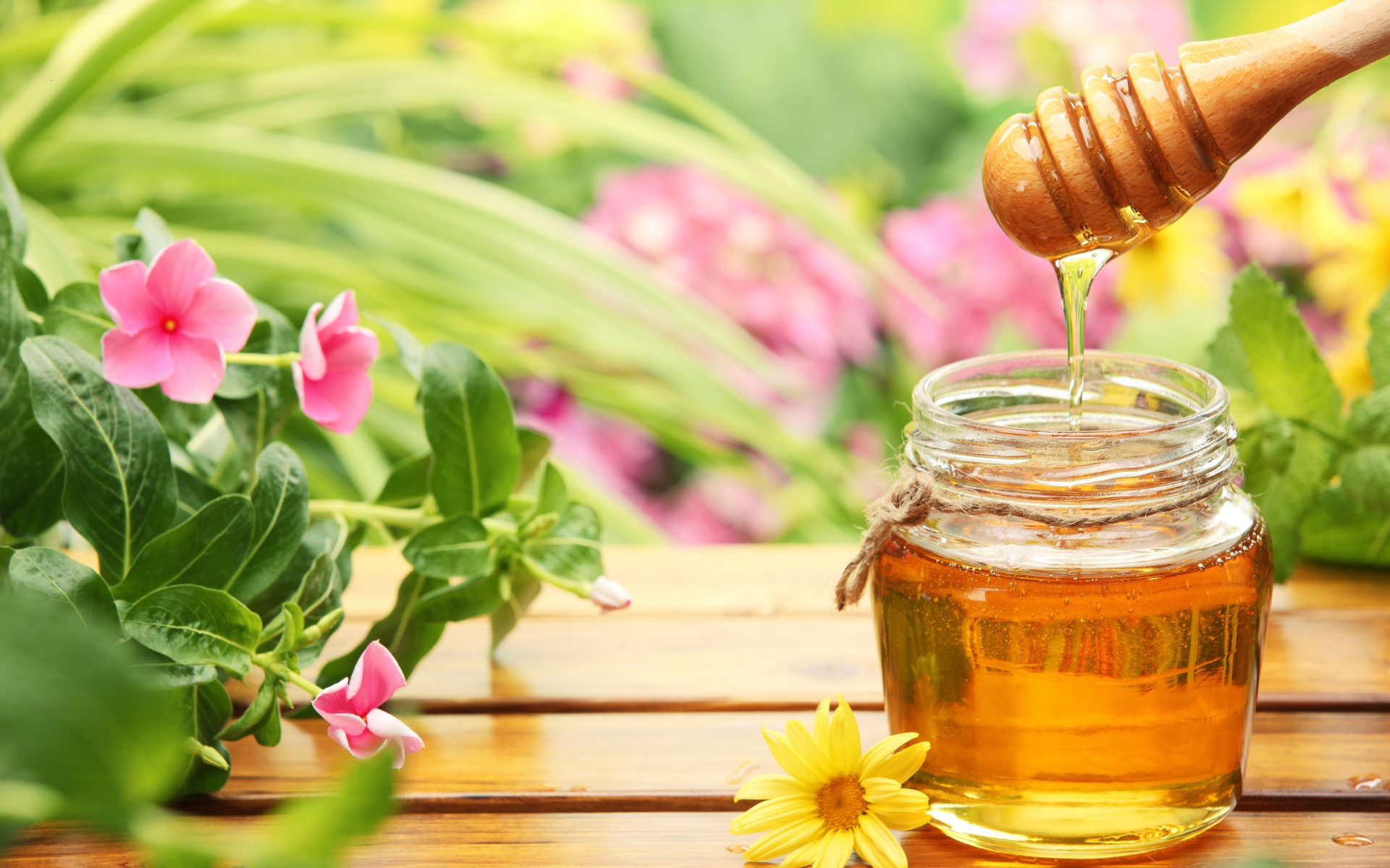 Банка ароматного меда на столе с цветами