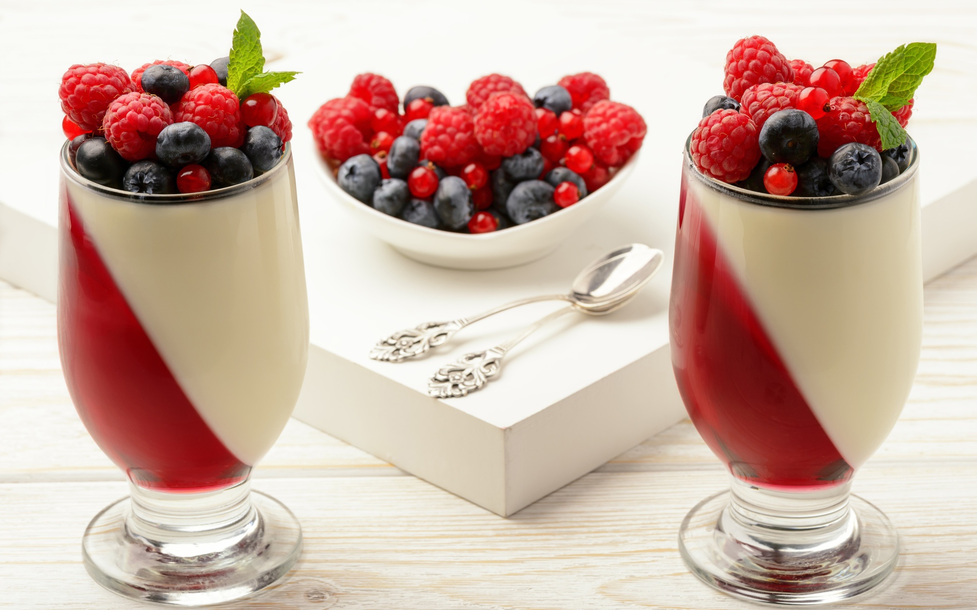 Двухцветный десерт с ягодами на столе 